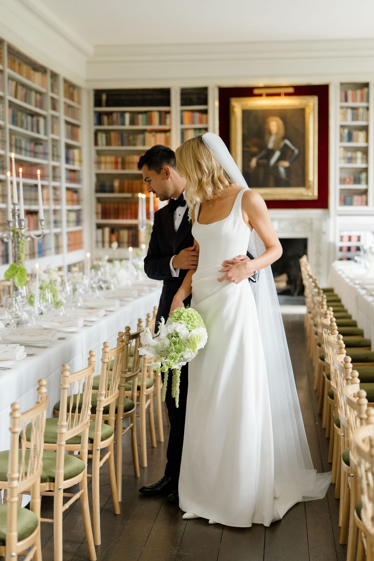 Bride and groom share an intimate moment in an elegant library wedding reception venue.