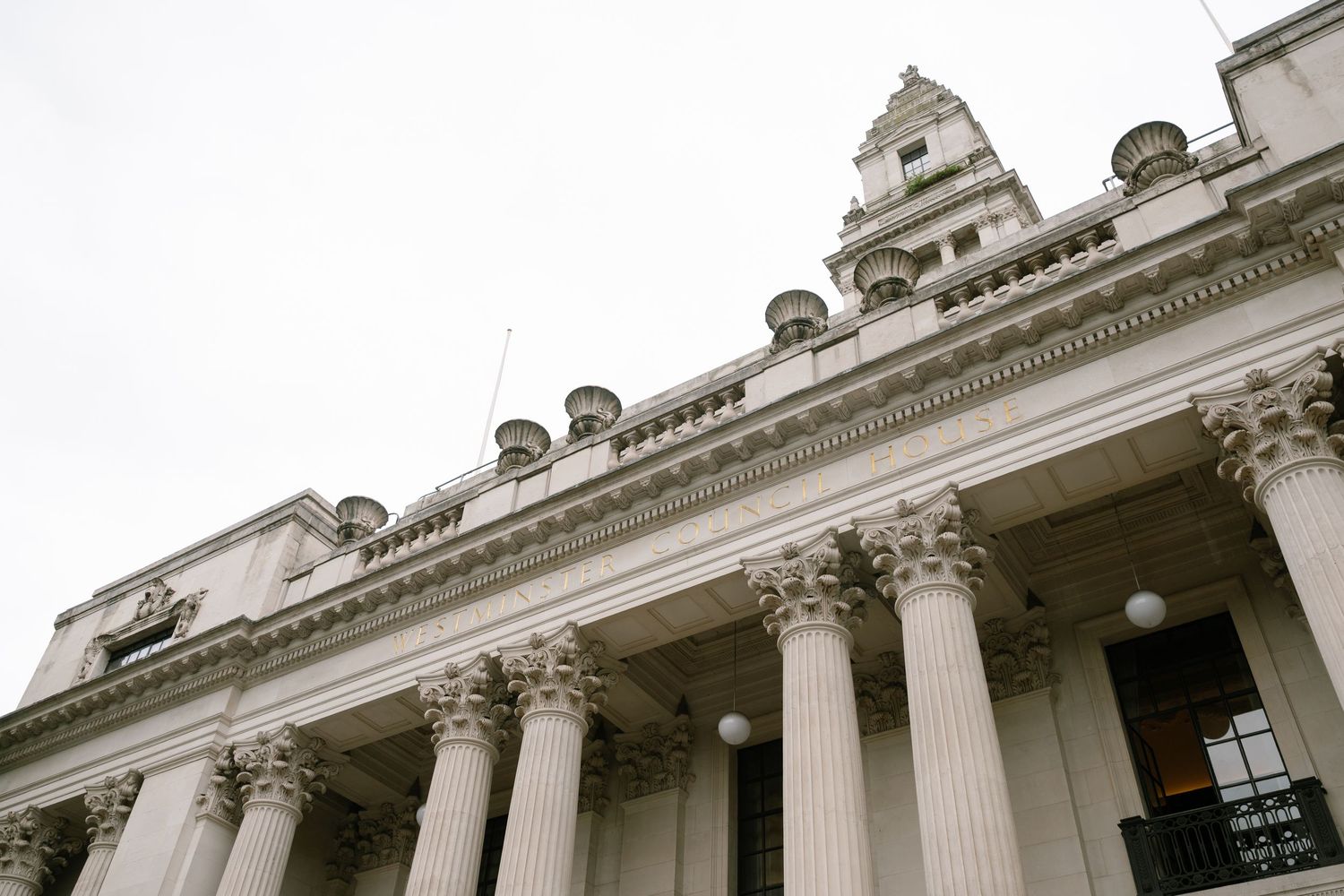 Exterior view of a grand neoclassical building with columns and ornate architectural details.