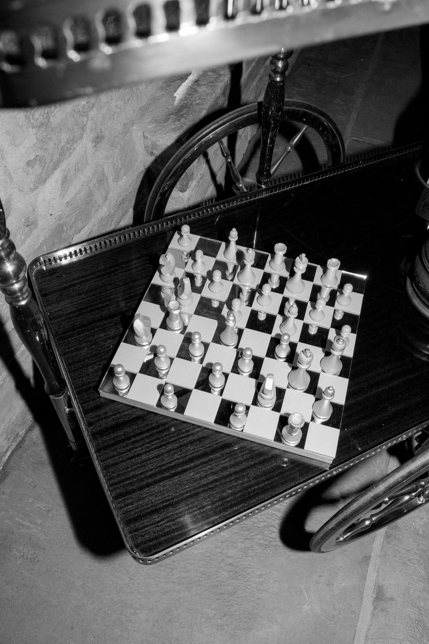 Black and white sequence showing chess pieces arranged on a vintage camera case.