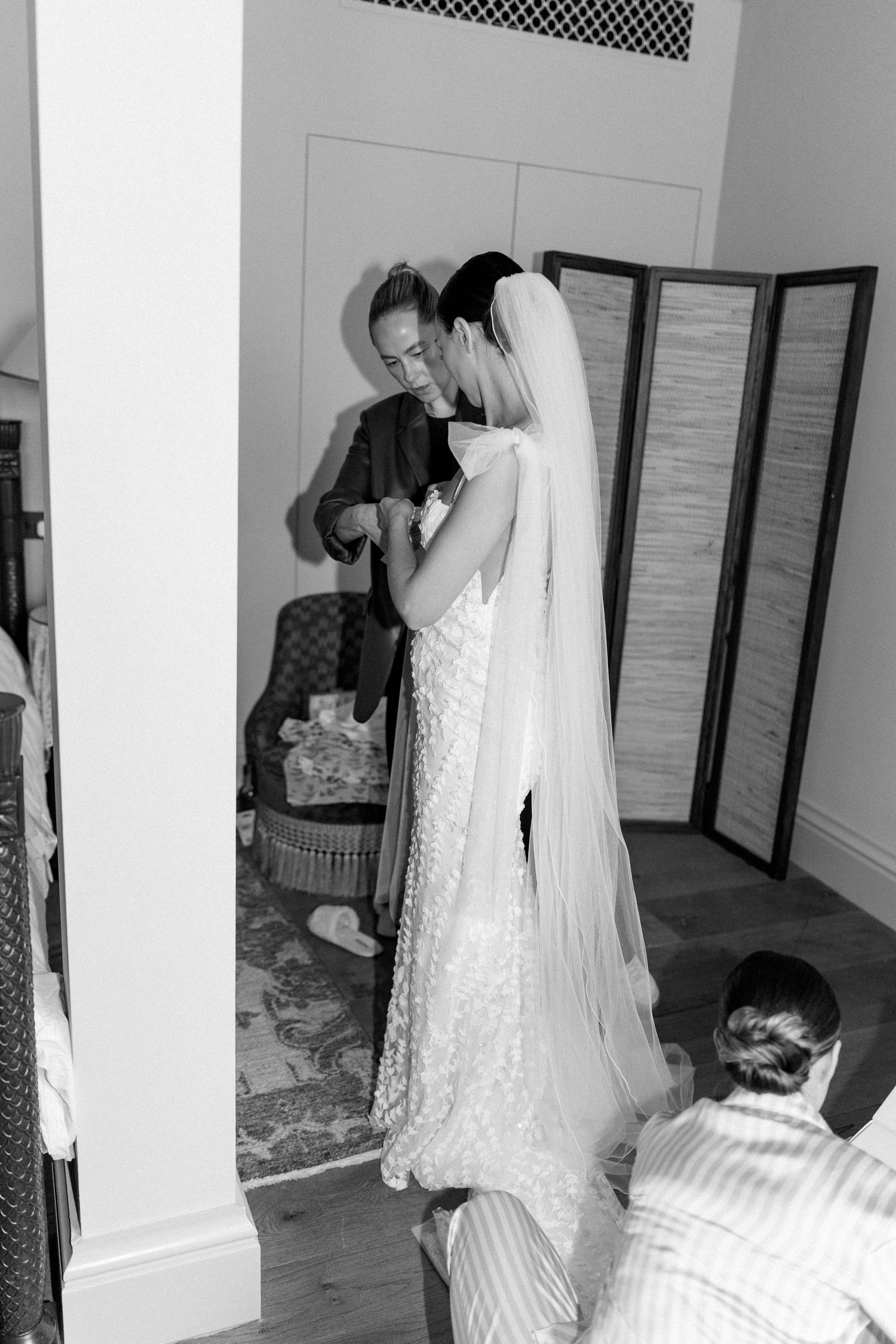 Wedding preparation scene with flowing white veil and dress in an elegant room.
