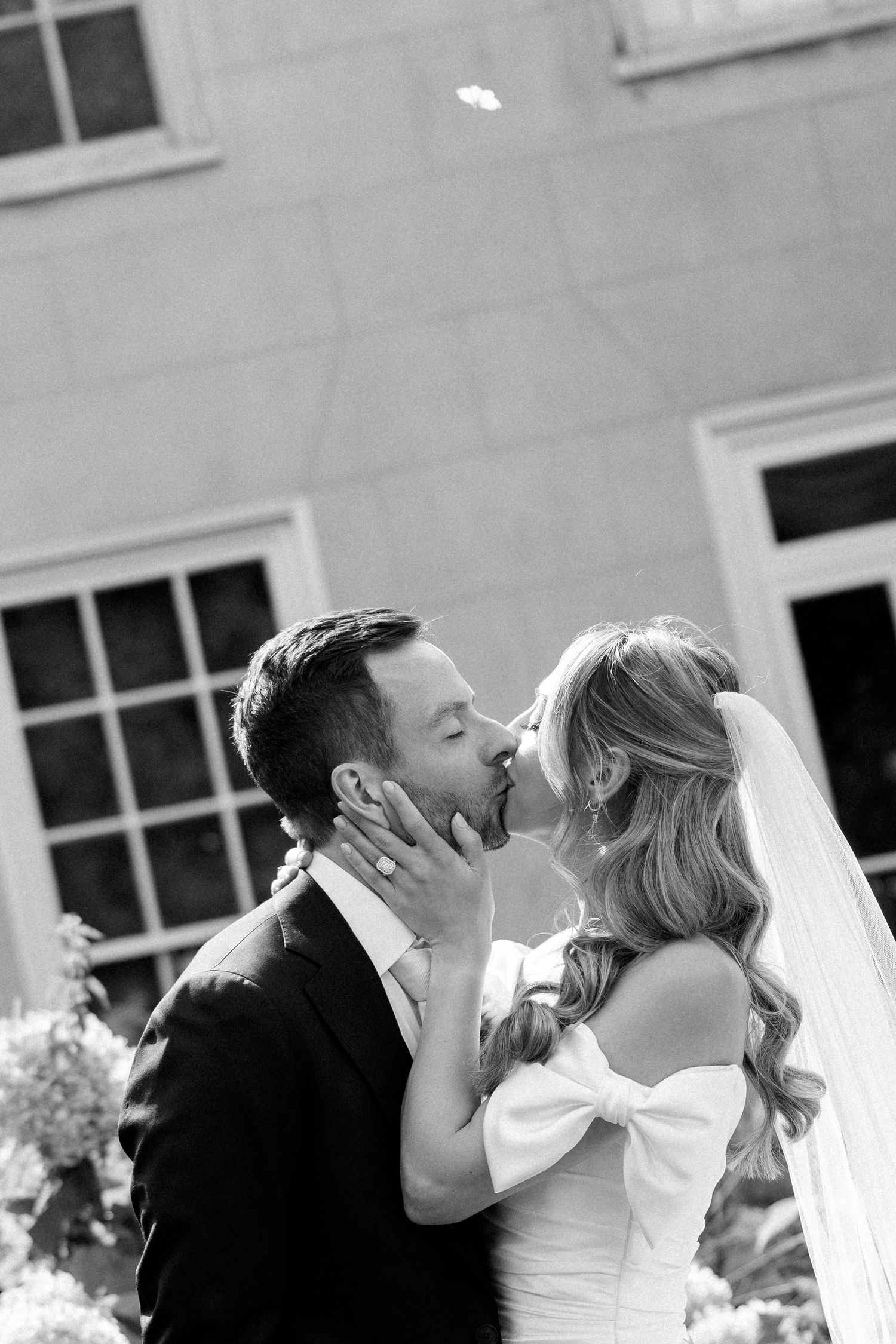 A series of romantic black and white wedding photos showing tender kisses between the newlyweds.
