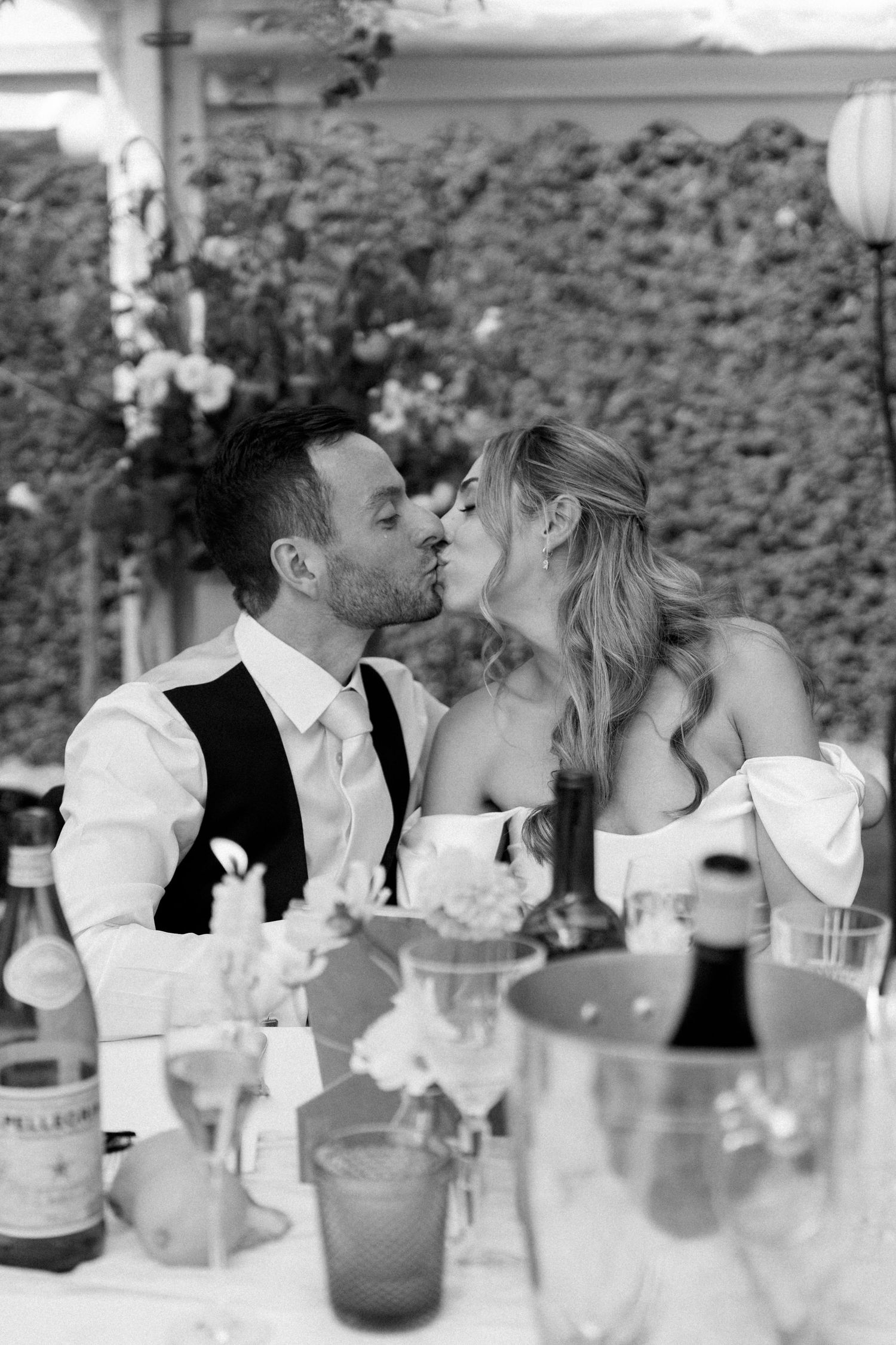 Intimate moment shared at wedding reception table with elegant place settings.