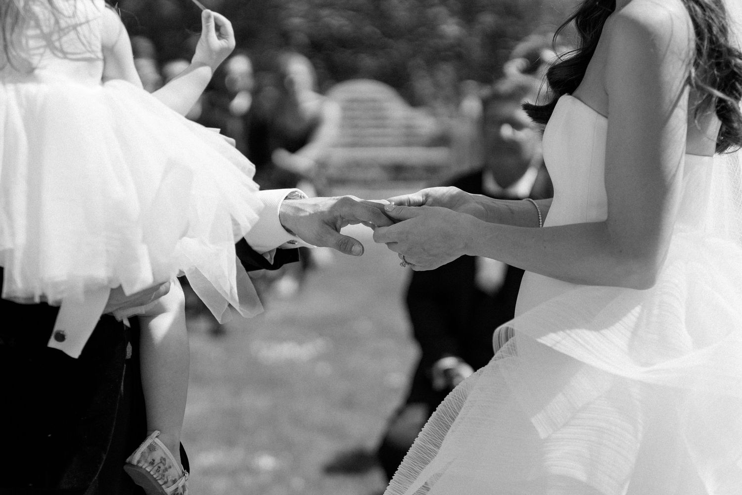 Close-up of flowing white wedding dress during outdoor dance celebration.