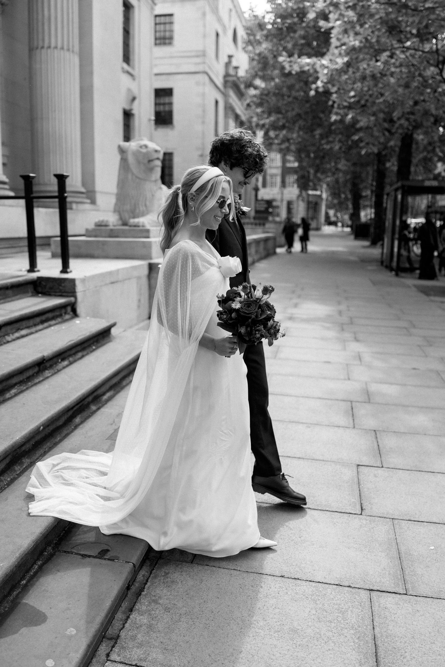 Artistic sequence of wedding photos capturing movement and flow of a dress against architectural backdrop.