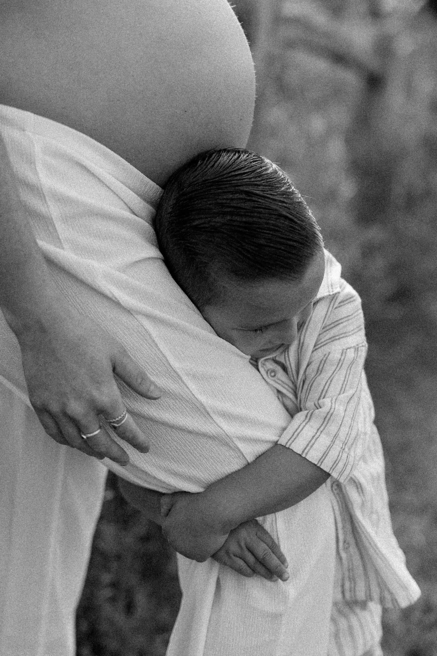 Close-up black and white portrait showing tender embrace in white clothing.