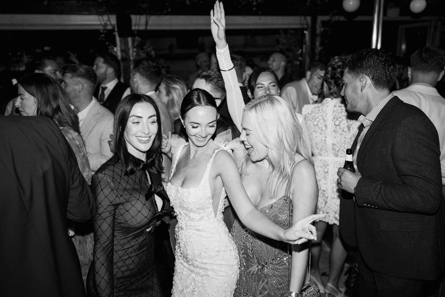 Energetic dancing and celebration at nighttime wedding reception.