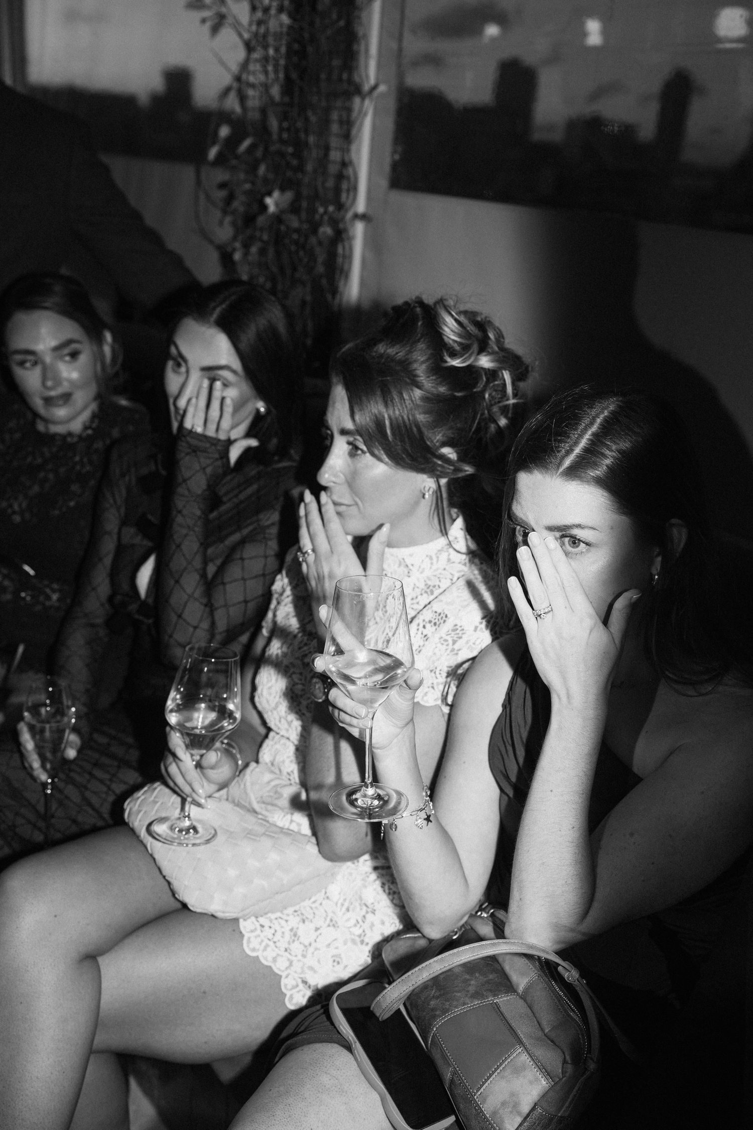 Emotional wedding guests react during a touching moment at the reception.