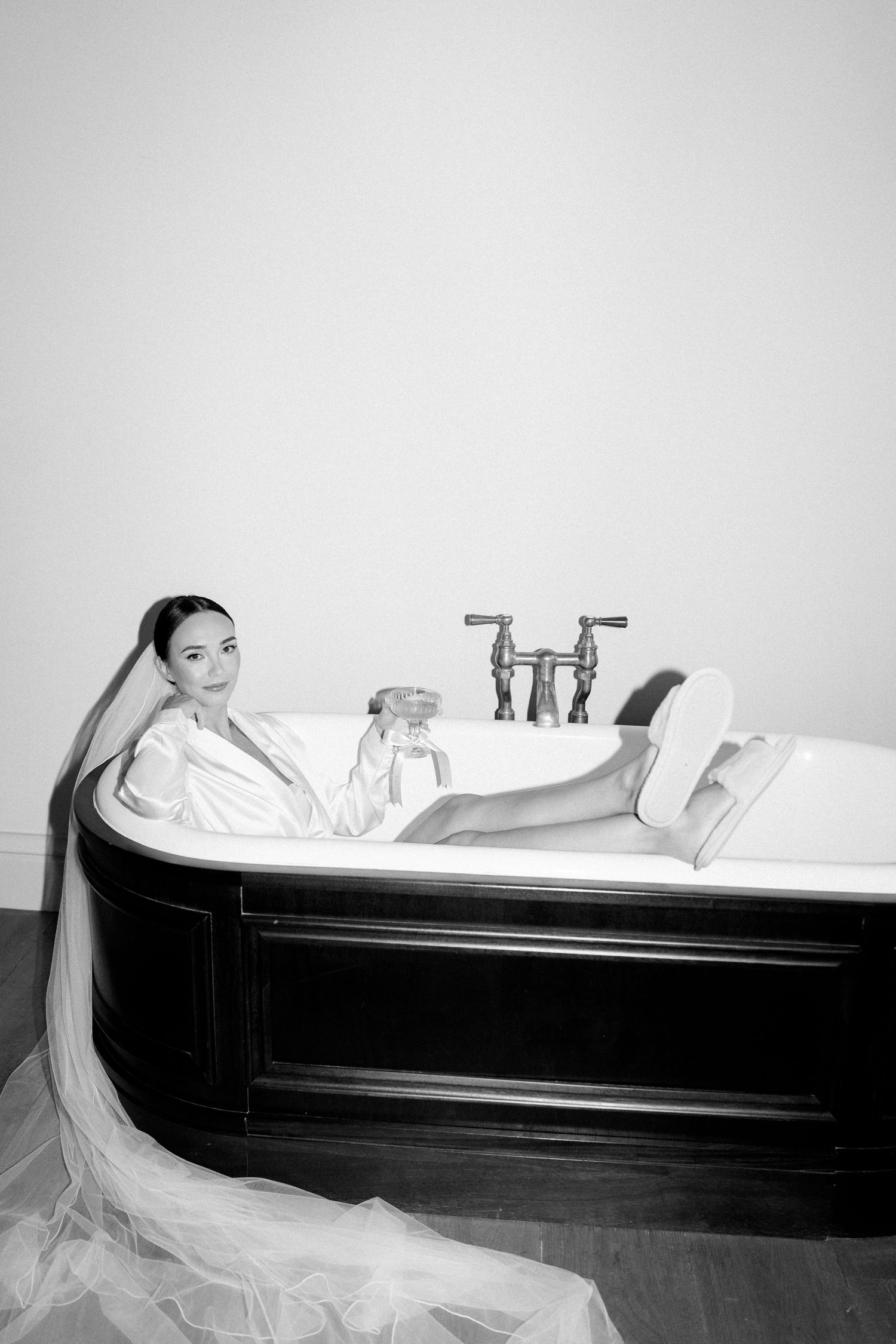 Minimalist bathroom scene with person relaxing in classic clawfoot tub.
