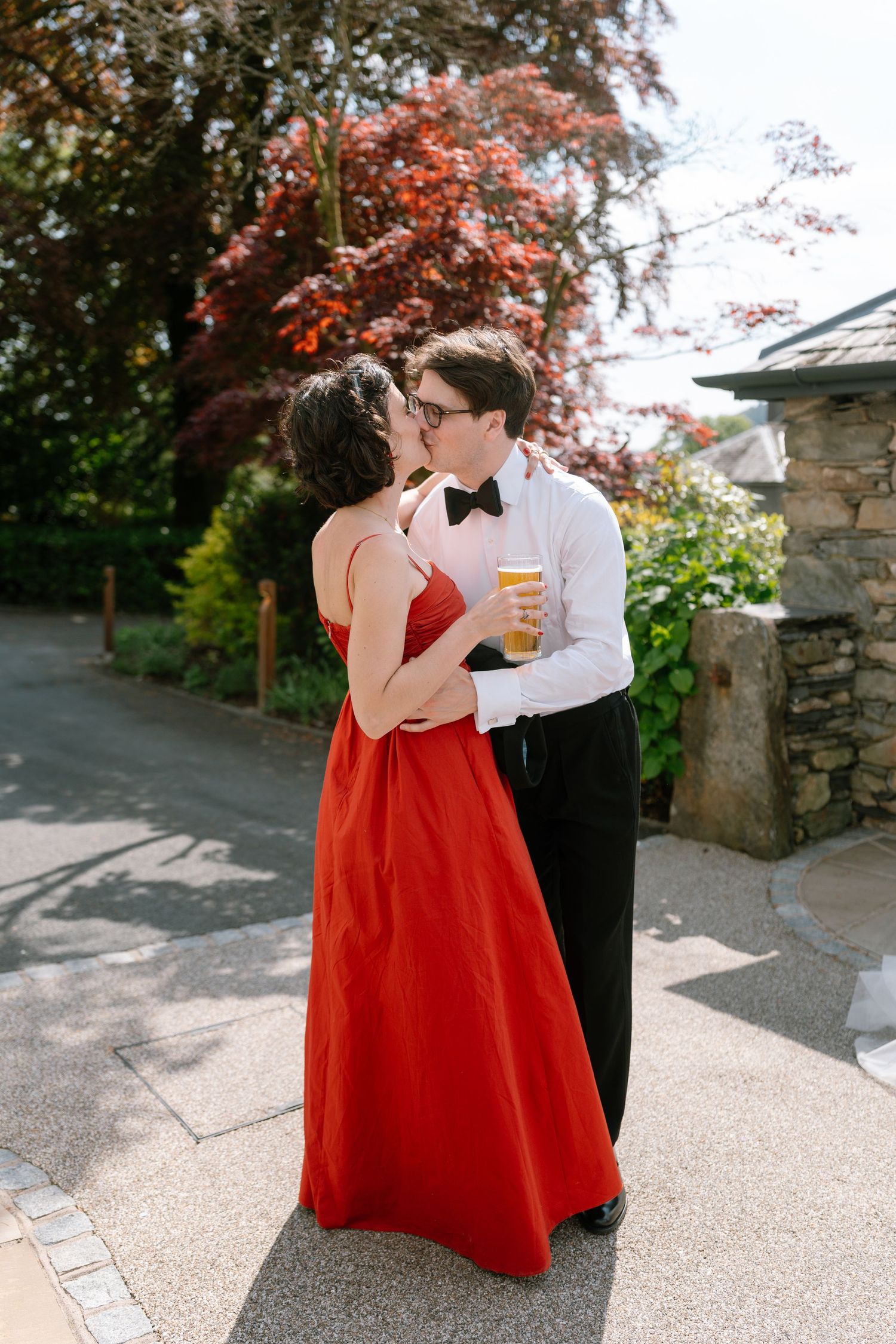 A couple in formal attire shares a moment together at an outdoor wedding reception.