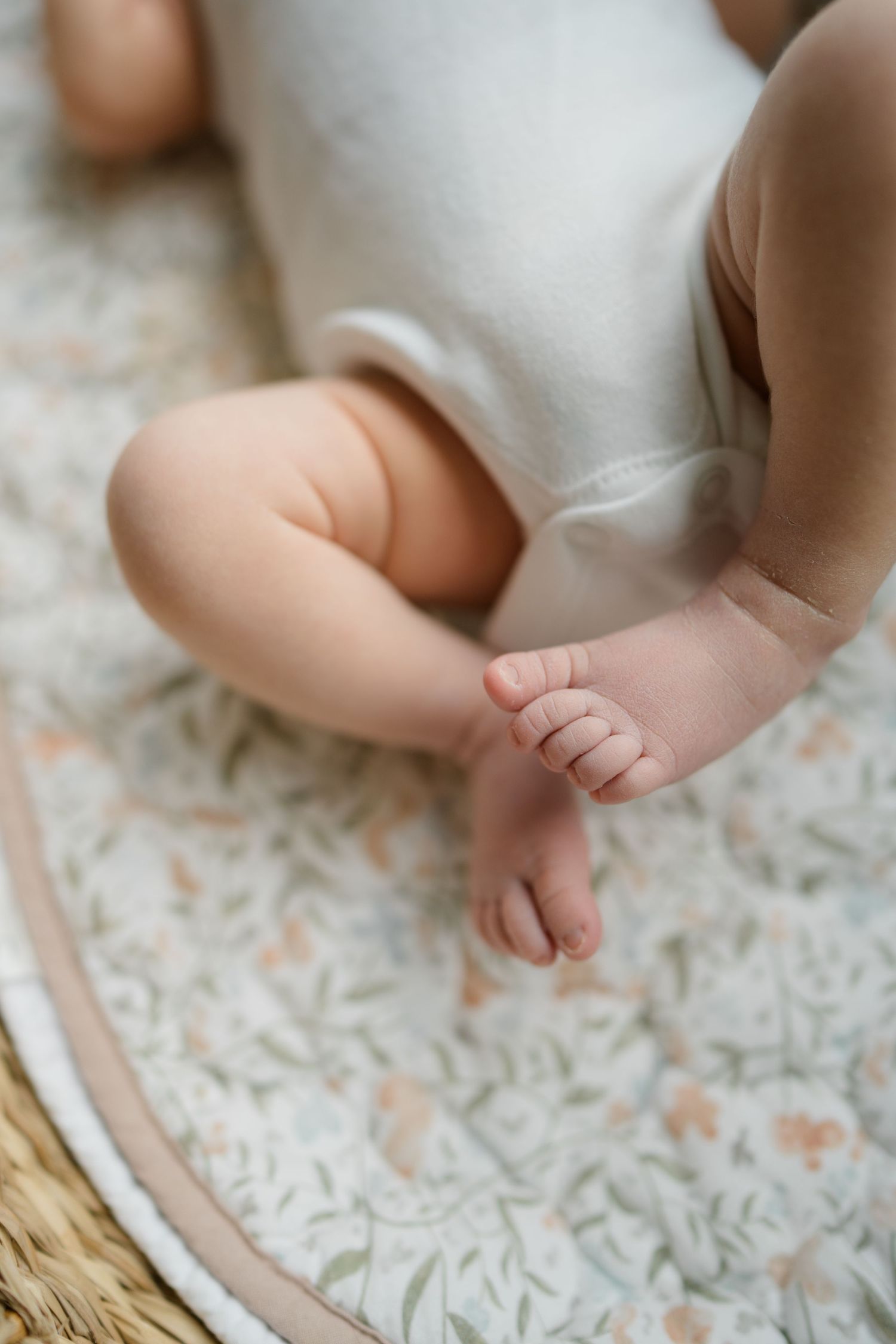 Close-up of tiny baby feet resting on textured white fabric.
