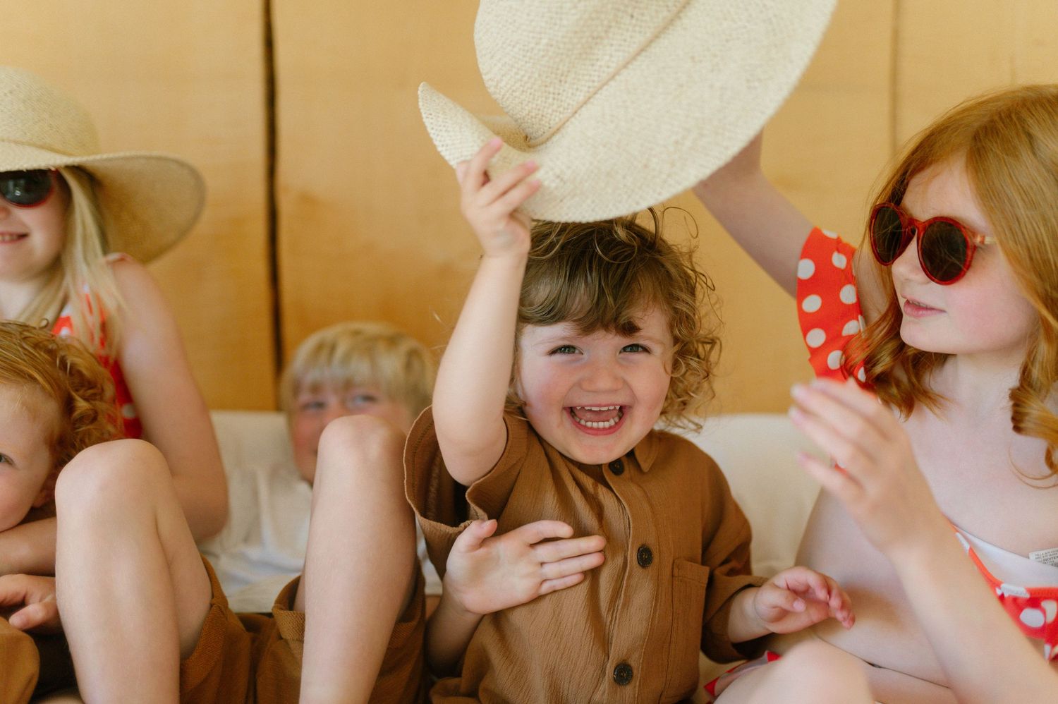 People relaxing together wearing summer hats and swimwear in natural lighting.