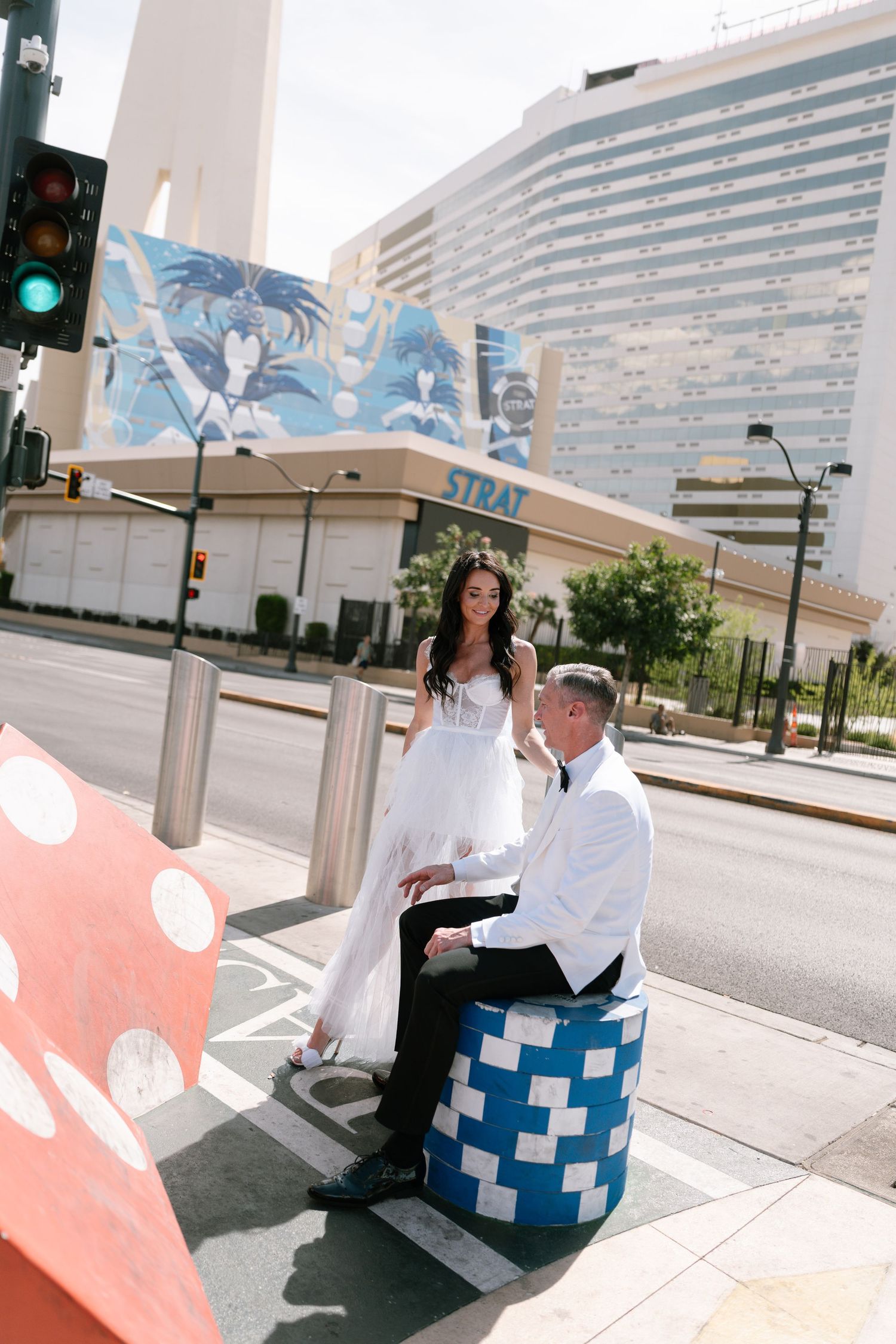 A couple sitting on a blue and white checkered bench in front of an urban building.