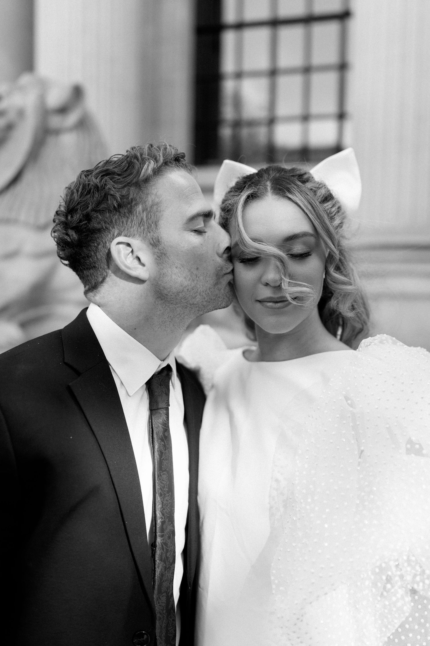 Intimate black and white portrait of a couple in formal attire.