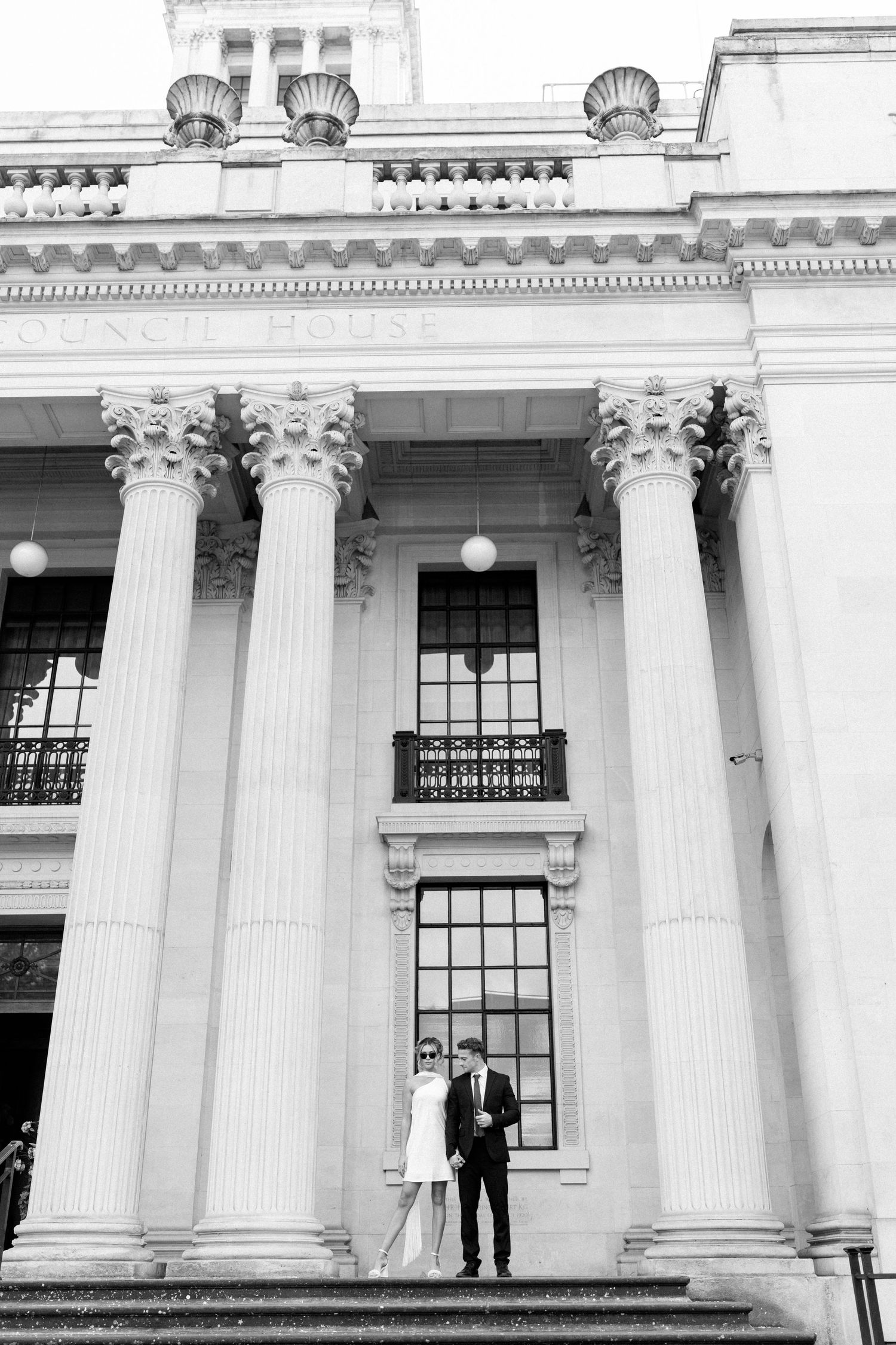 An elegant building facade with massive white columns and ornate architectural details.