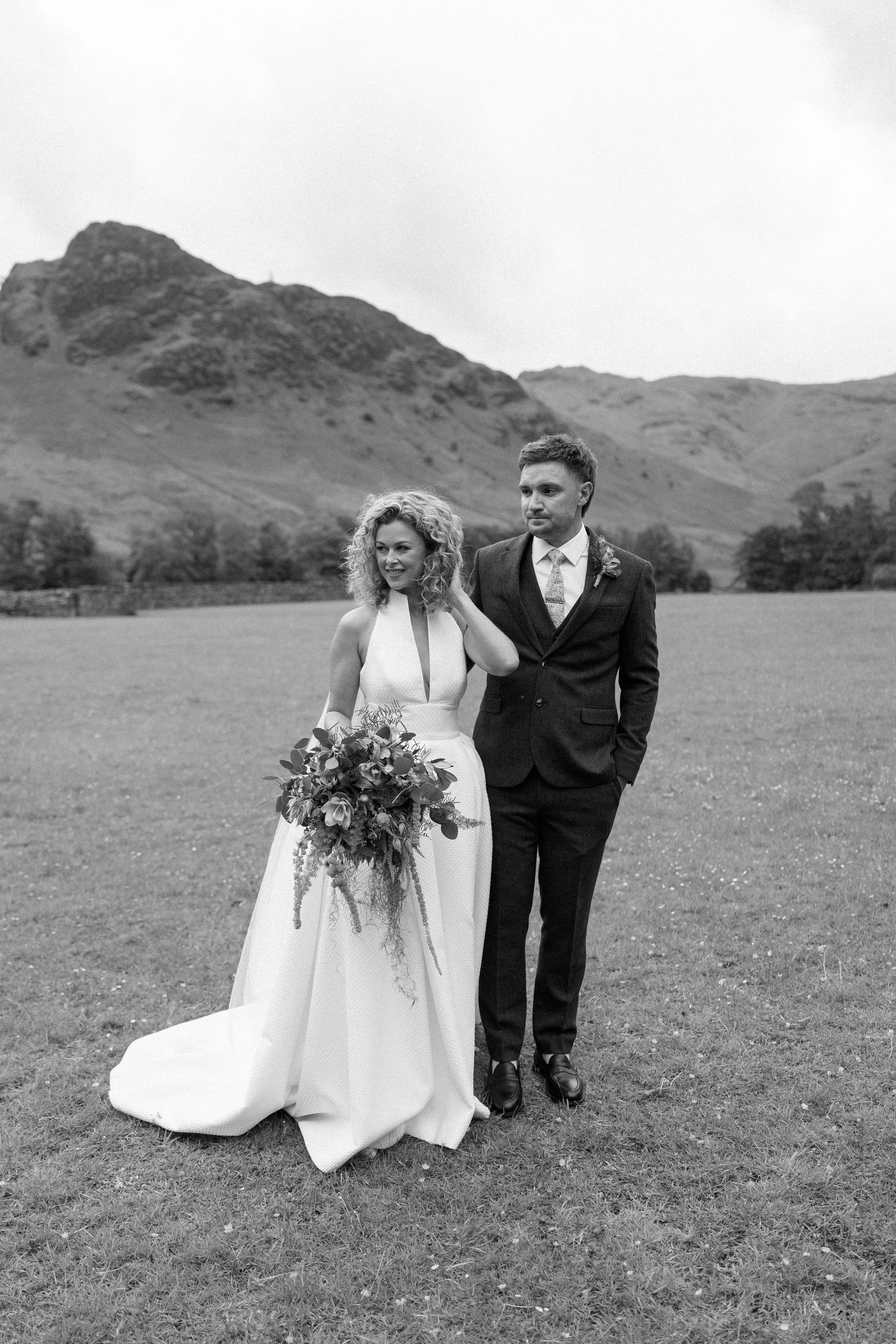 Romantic wedding portraits in a scenic mountain meadow with dramatic landscape views.