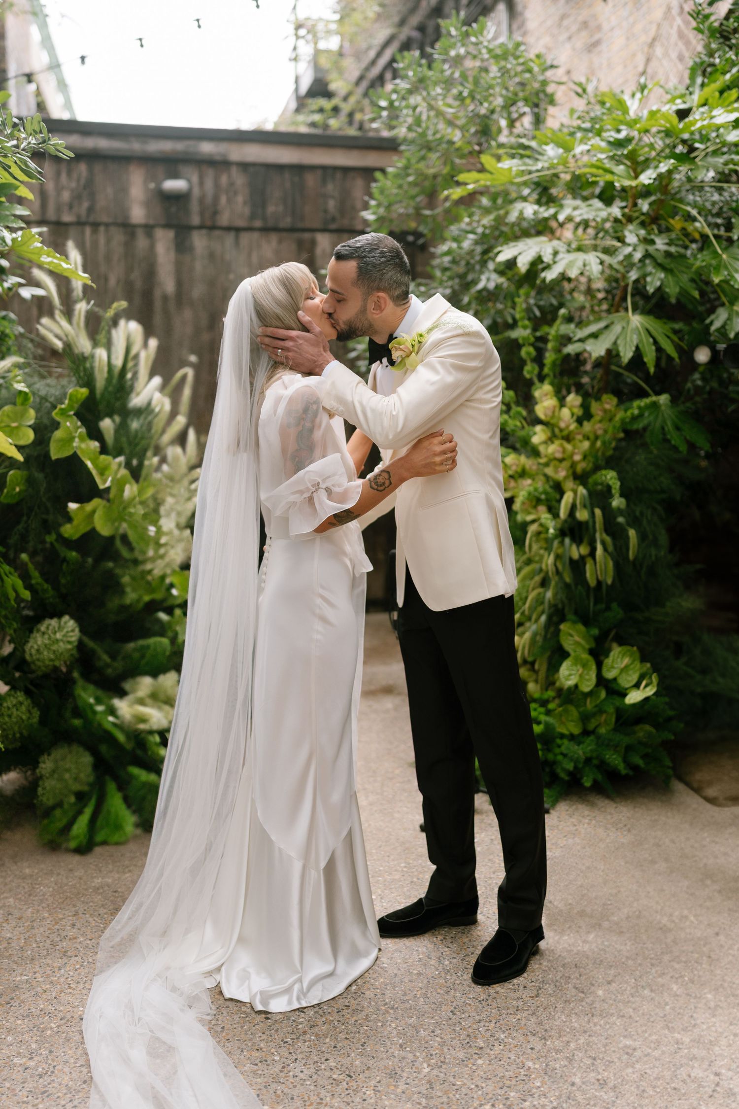 A tender moment captured during a wedding ceremony in a garden courtyard.