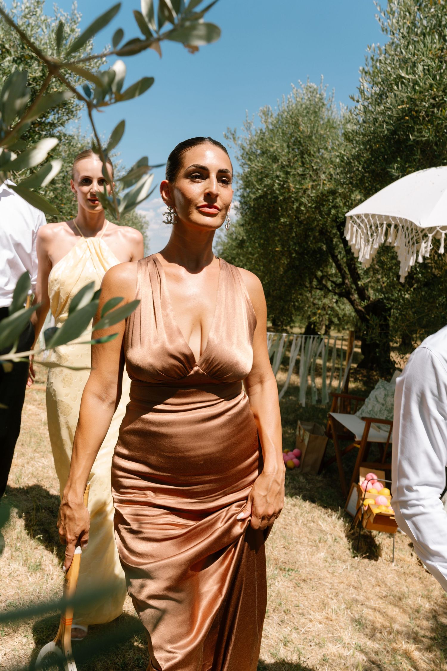 People enjoying outdoor festivities in an olive grove setting.