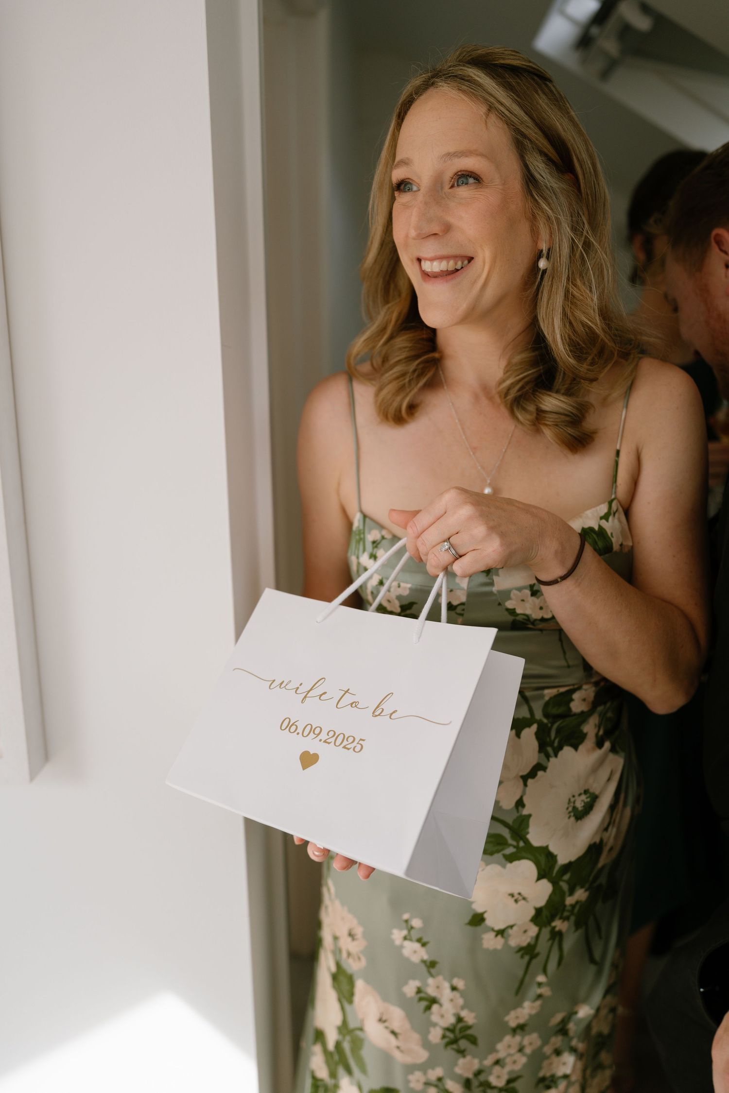 Person in floral dress holding note cards in naturally lit room.
