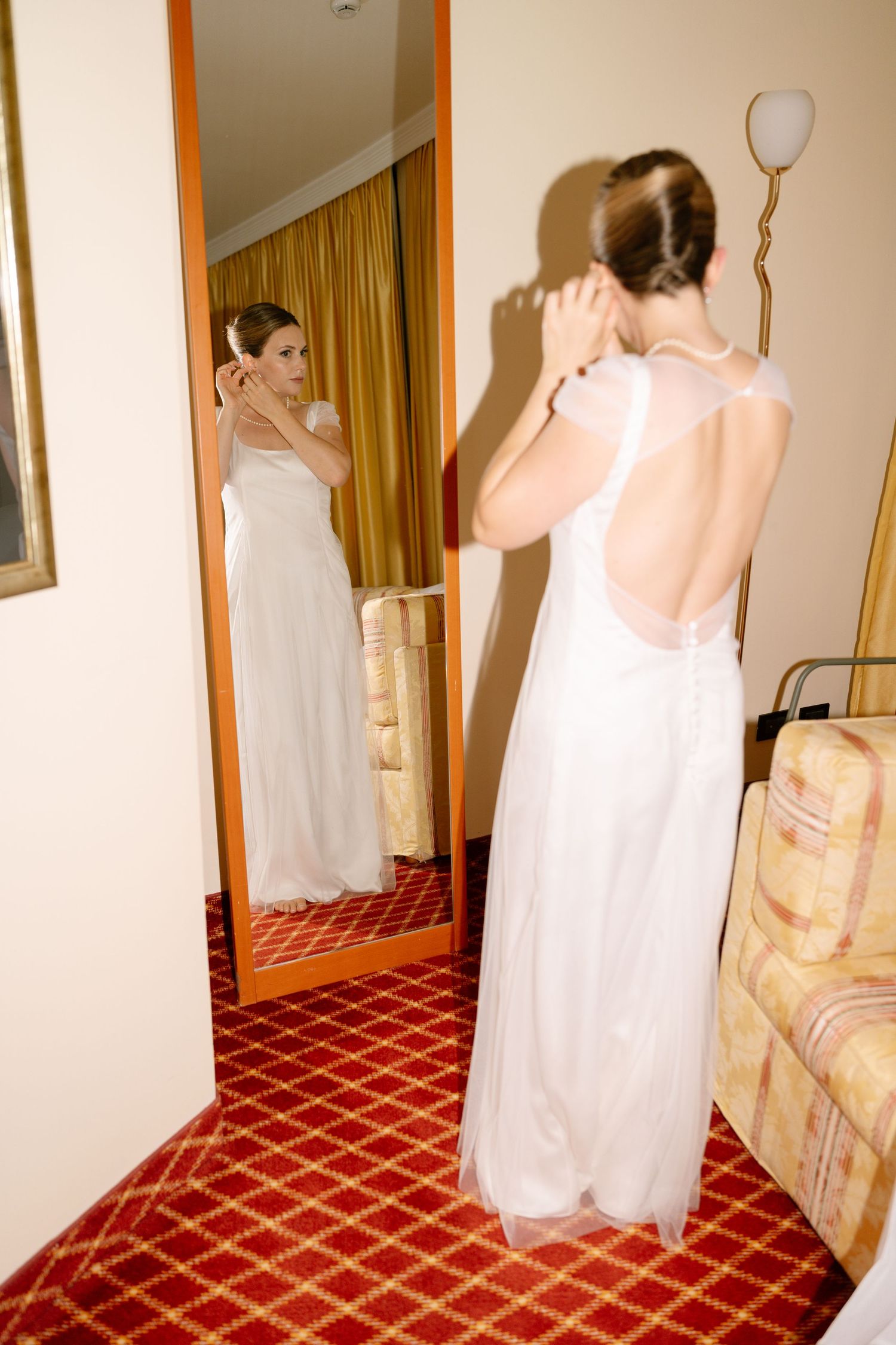 Multiple views of people in white dresses against a red carpeted floor.