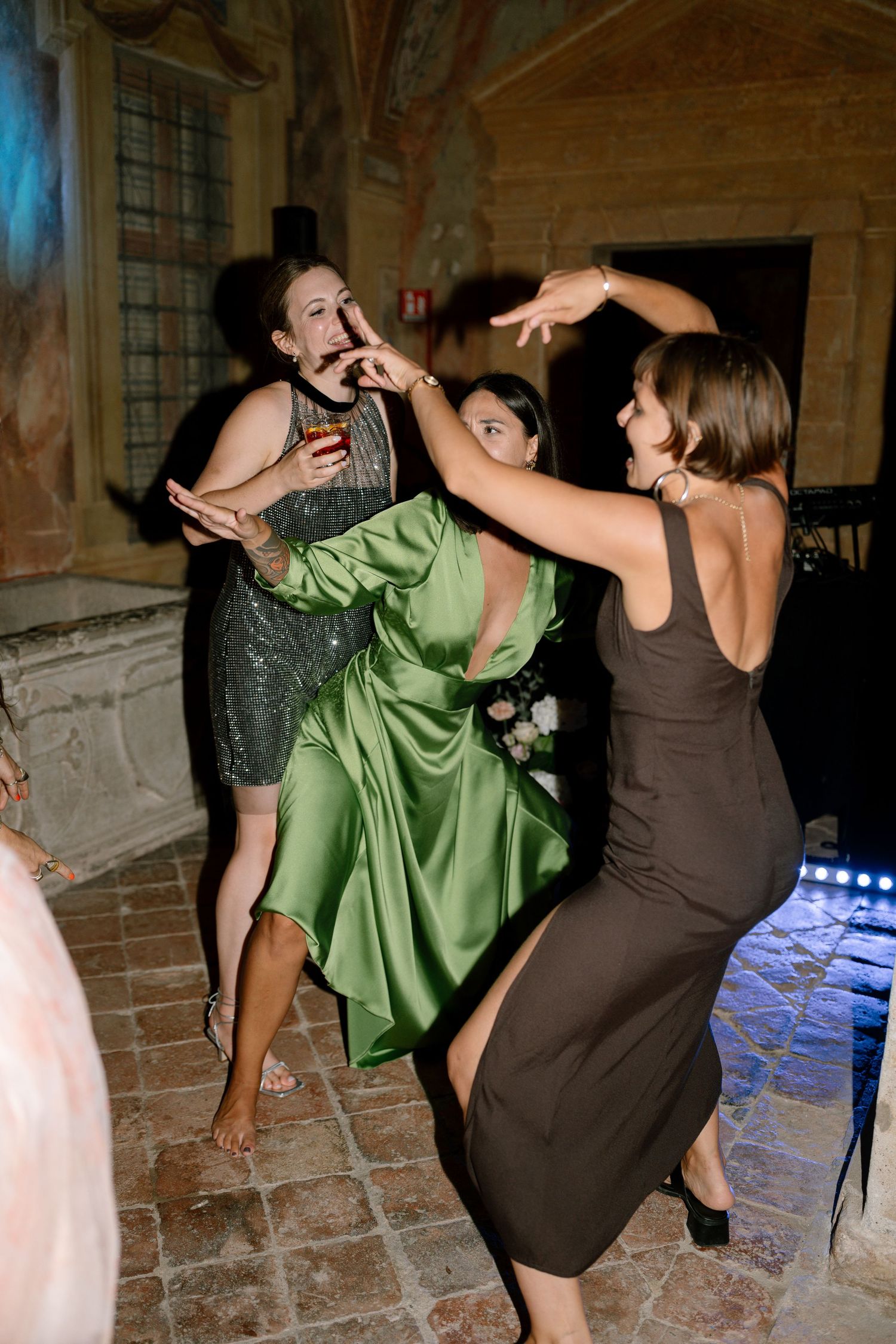 People dancing and twirling in formal attire at an elegant venue.