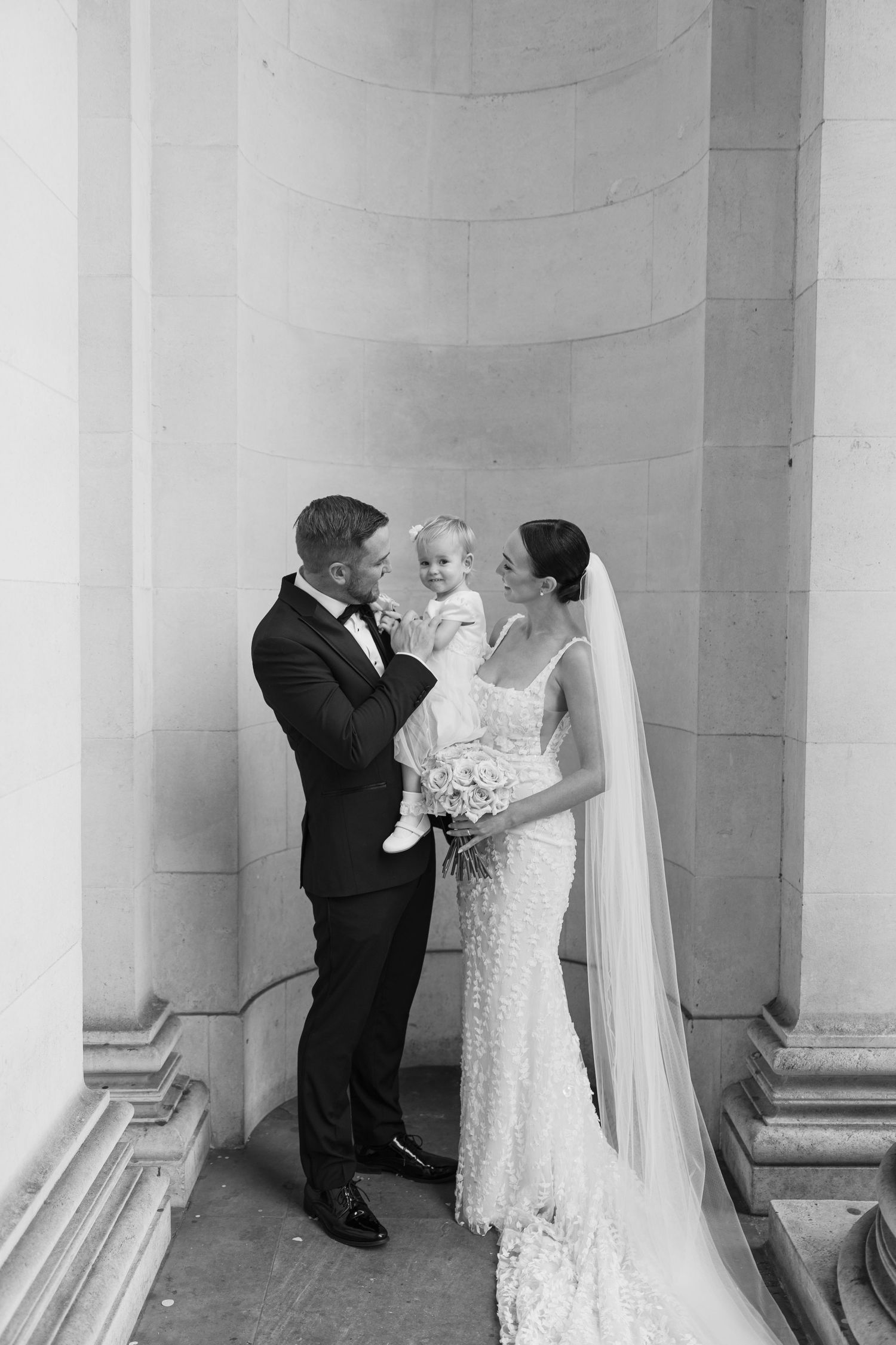 Black and white wedding portraits taken against a backdrop of classical stone columns.