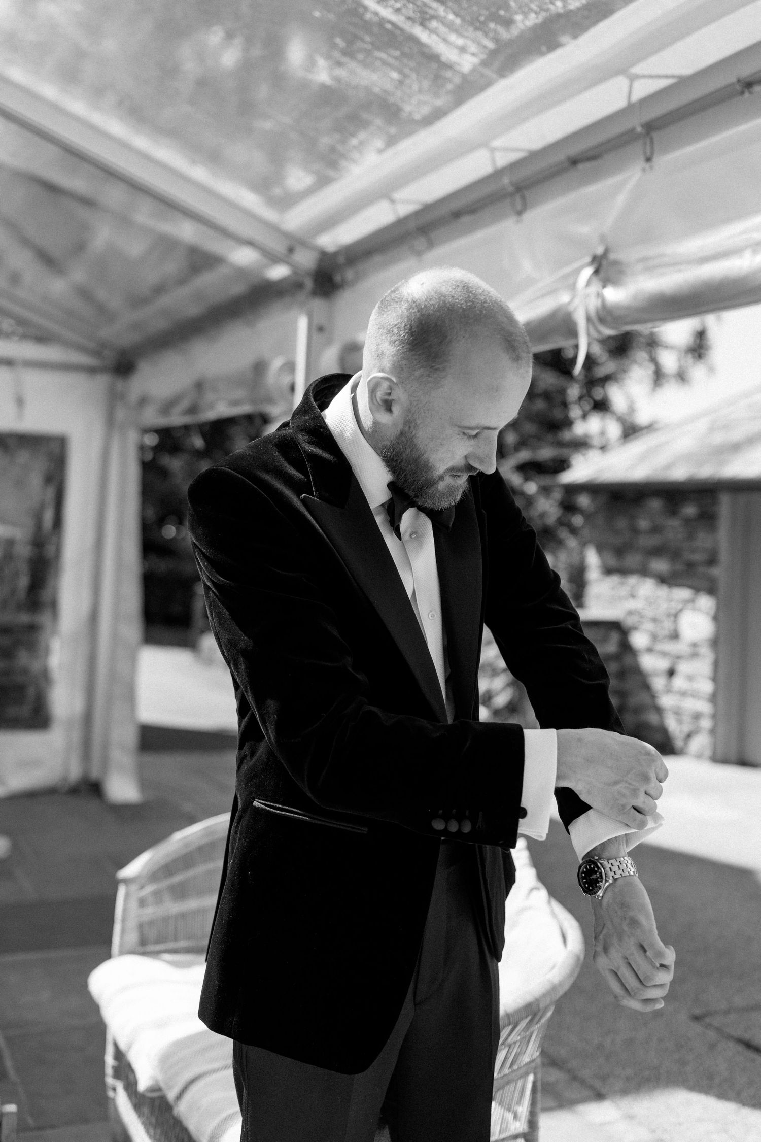 Men in formal attire under a white tent at an outdoor event.