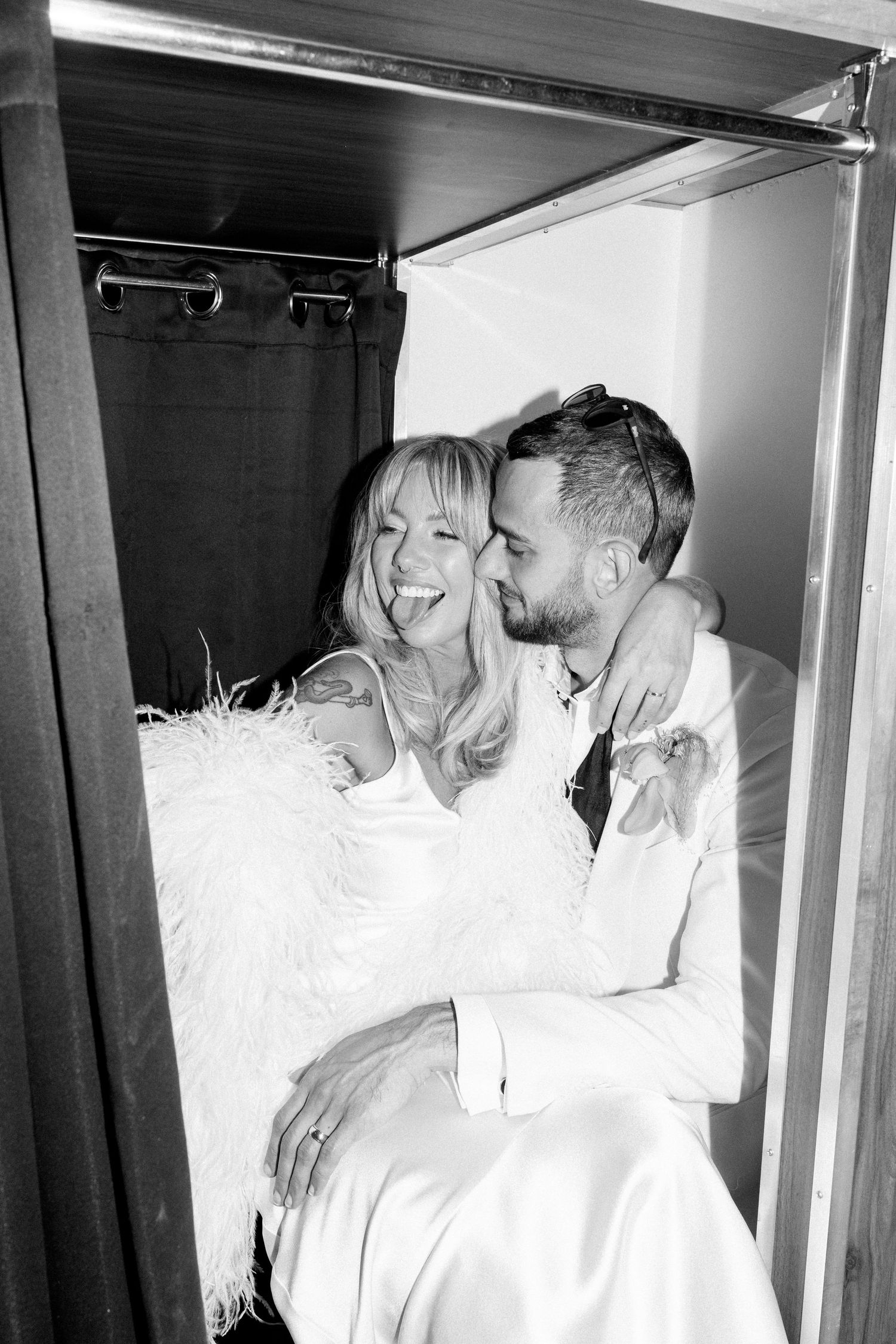 Intimate black and white photo shoot in a vintage photo booth setting.