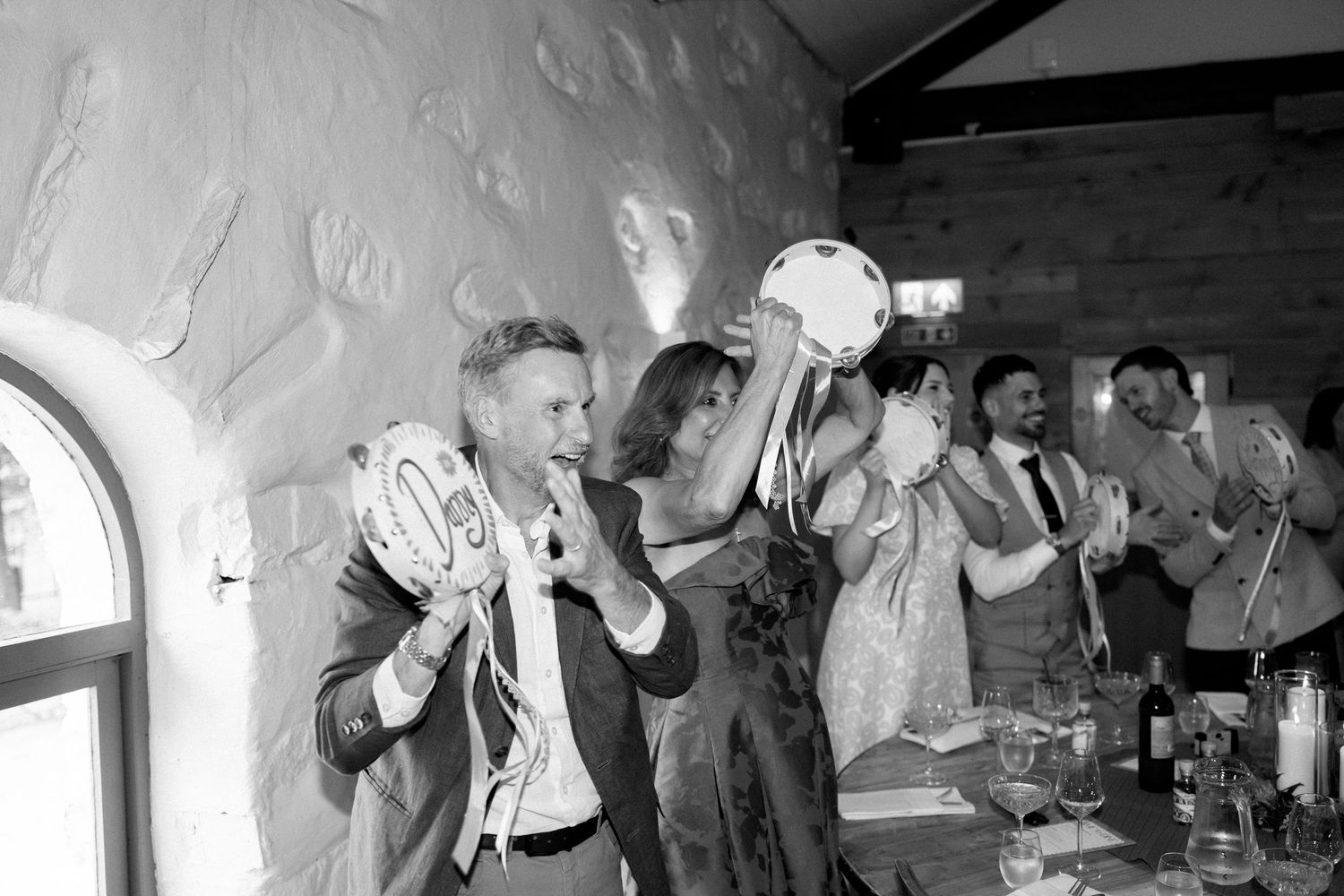 Black and white photos of wedding reception guests dancing and celebrating.