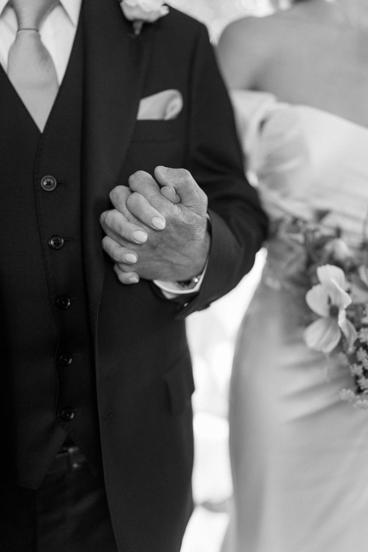 Black and white close-up shots of hands clasped together during wedding ceremony.