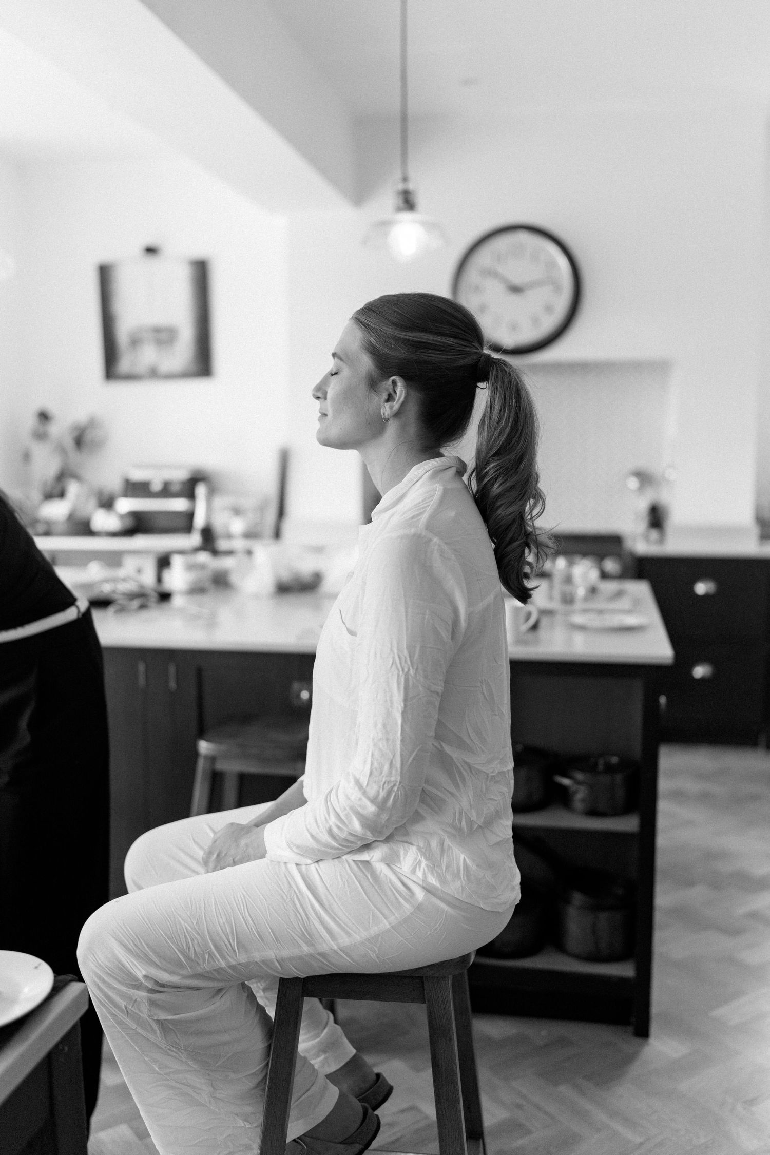 Woman in white sitting in salon chair during preparation.