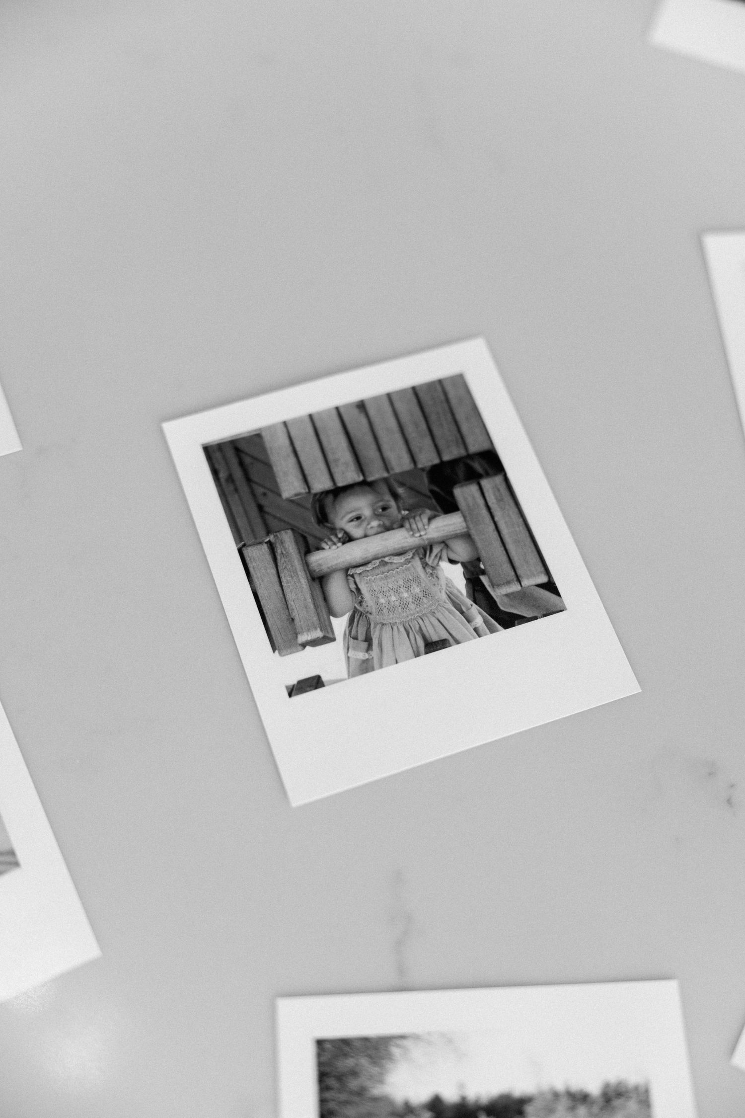 Collection of vintage black and white photographs arranged on a light gray surface.