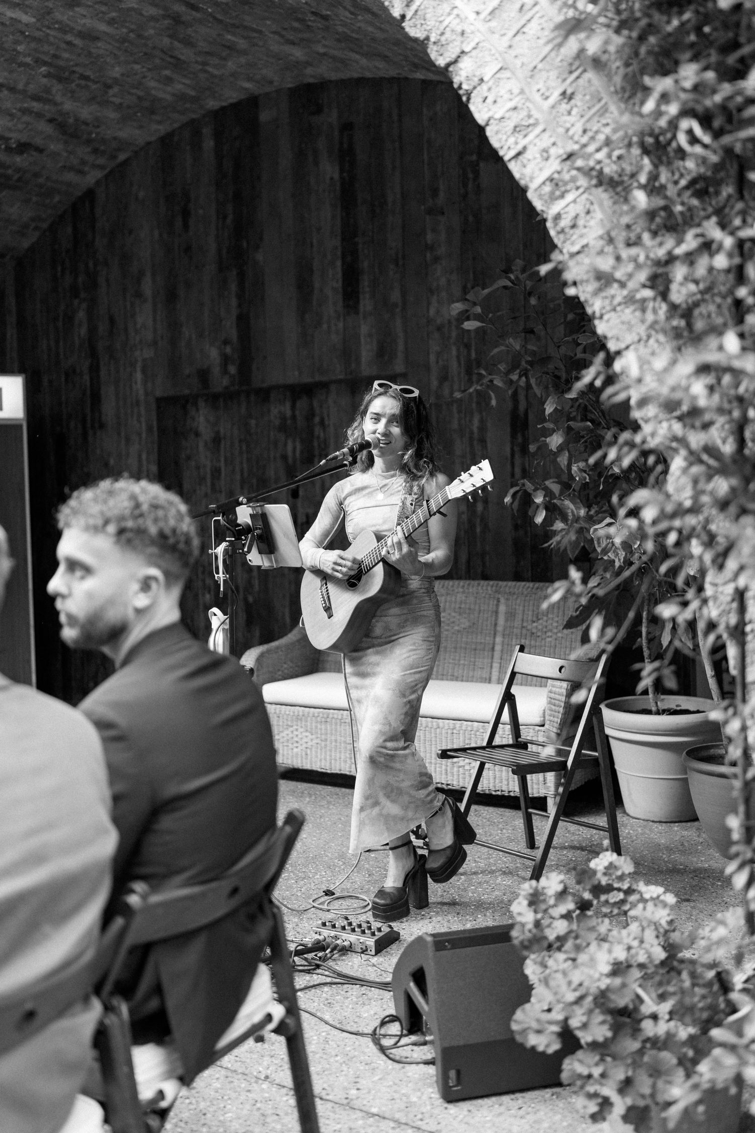 Black and white photos of musicians performing with guitars in an outdoor garden setting.