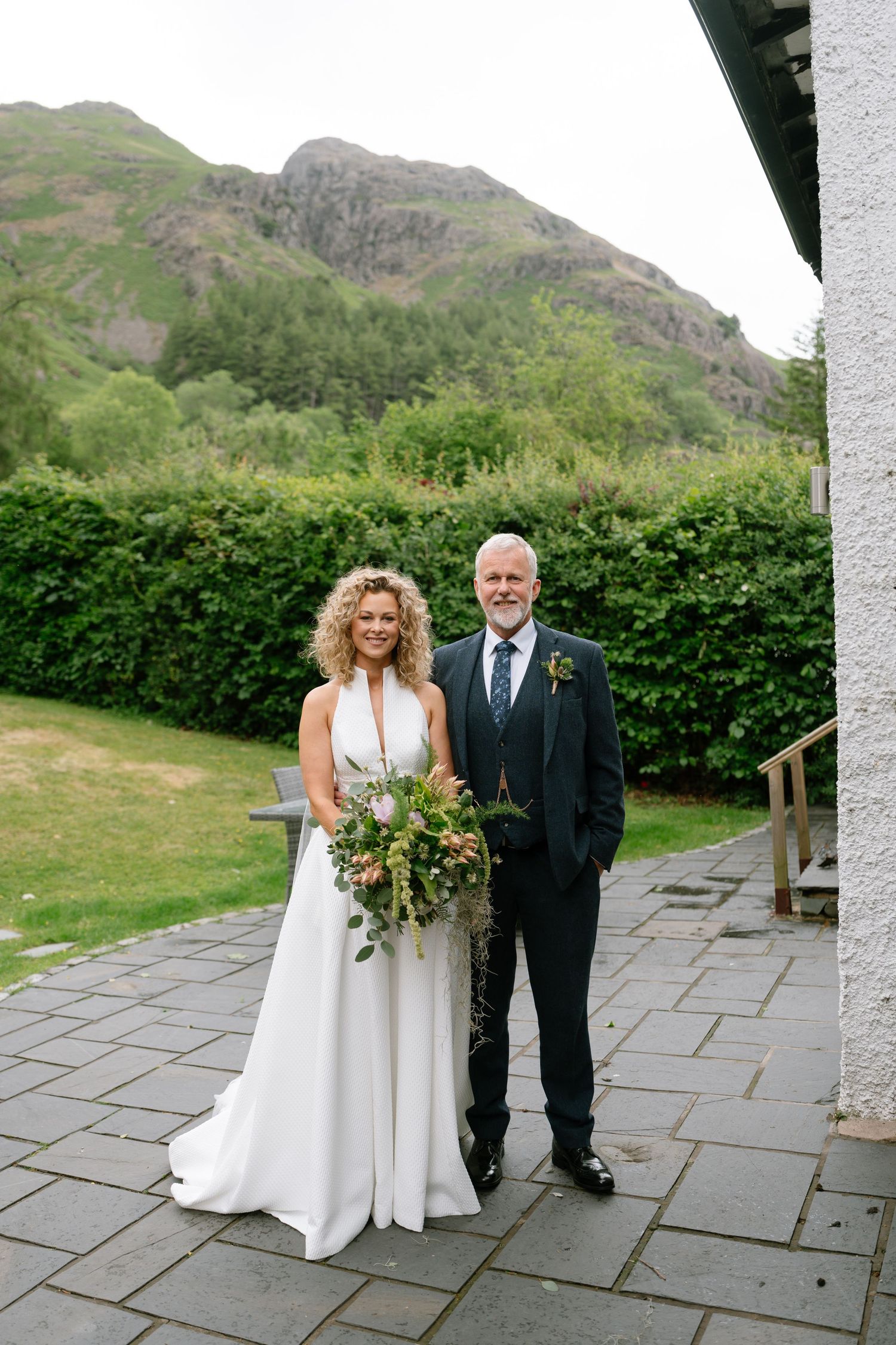 Wedding portraits taken on a stone patio with scenic mountain landscape in the background.