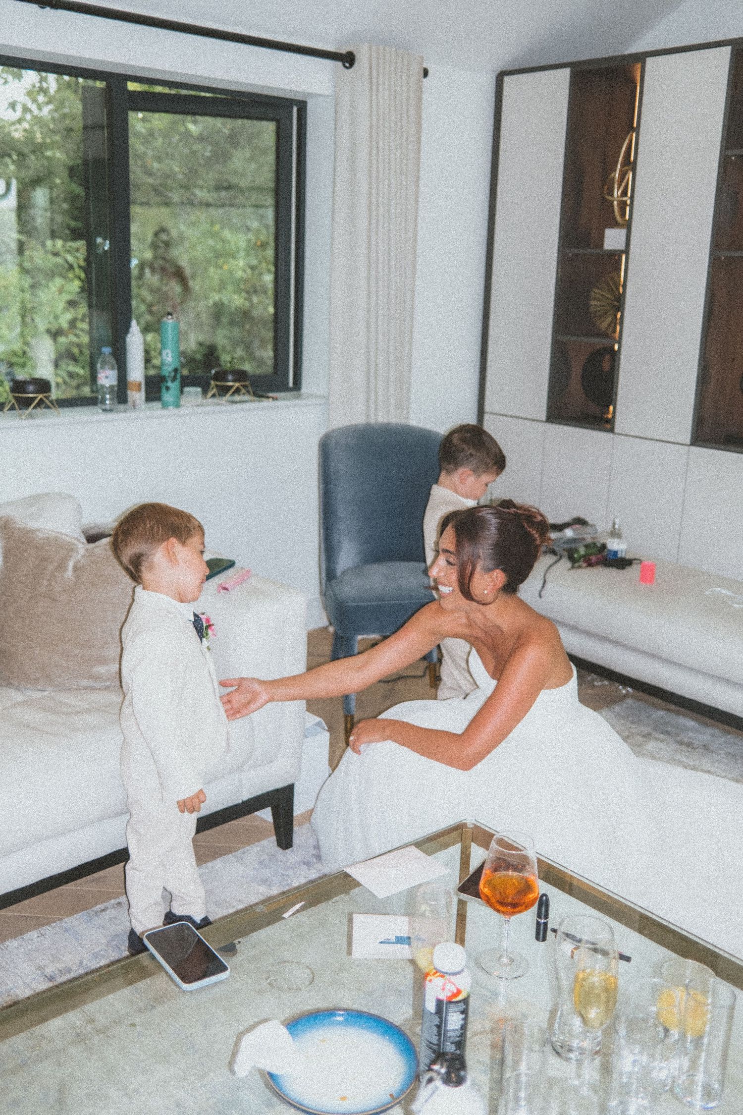 A sequence of photos showing someone in a white protective suit spraying disinfectant on surfaces in a modern room.