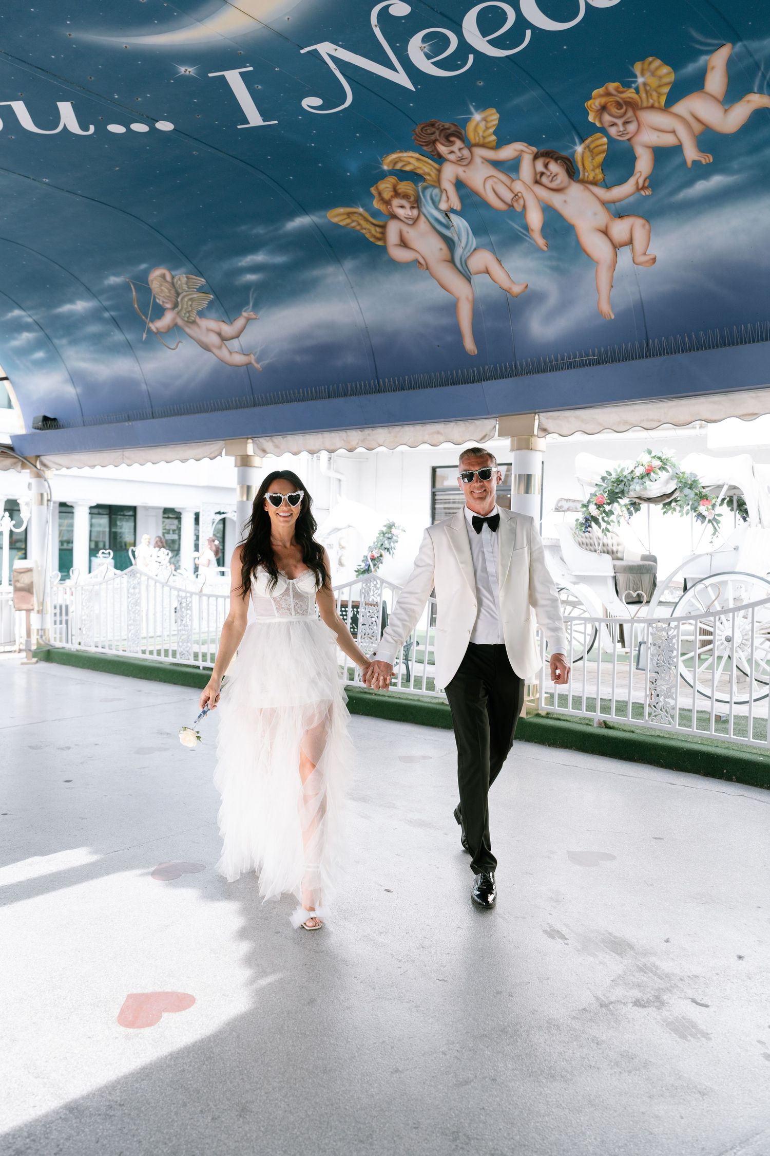 Wedding couple dancing under a blue ceiling decorated with cherub paintings.