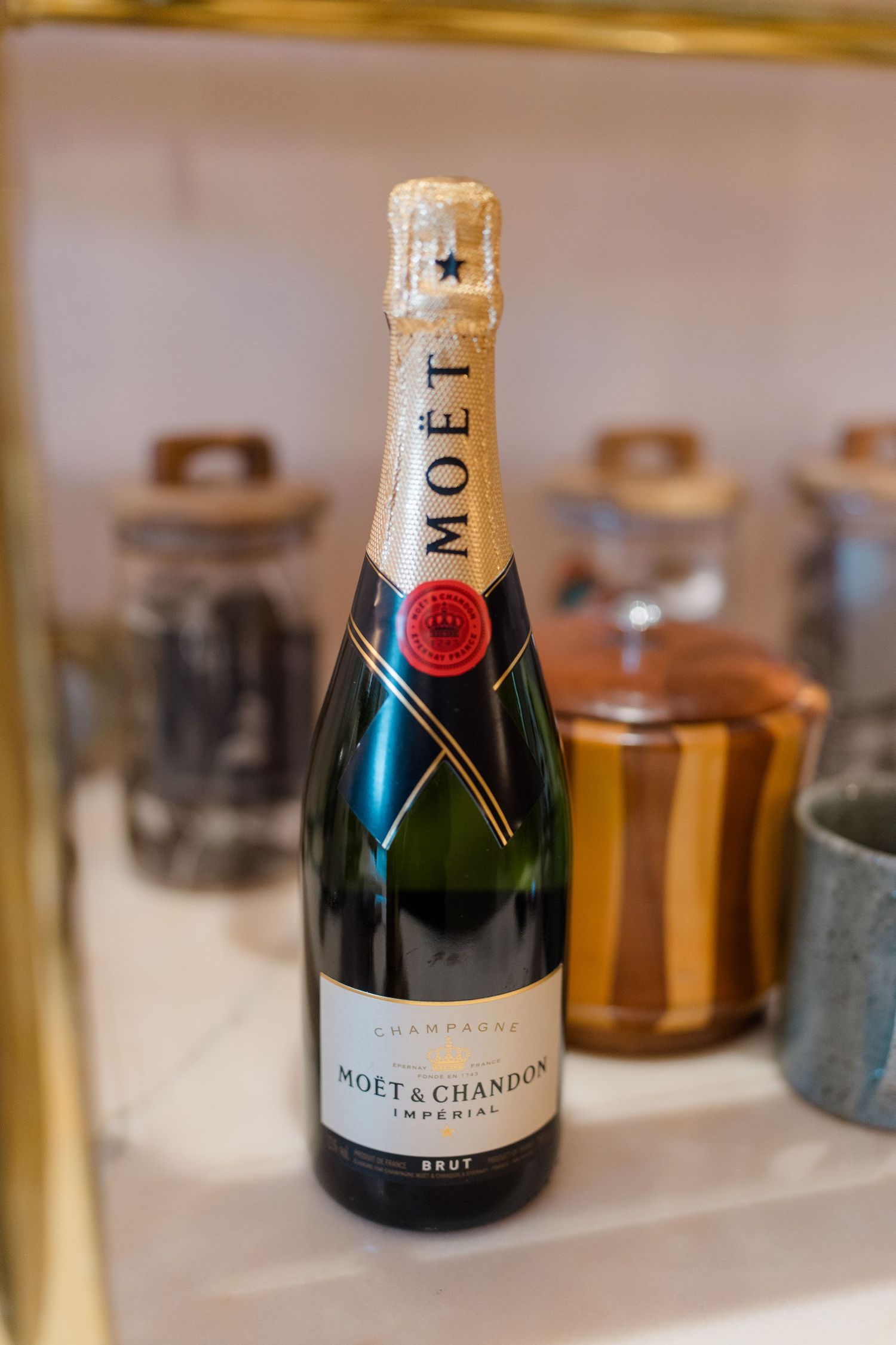 A bottle of Moet and Chandon Imperial Brut champagne displayed on a marble shelf.