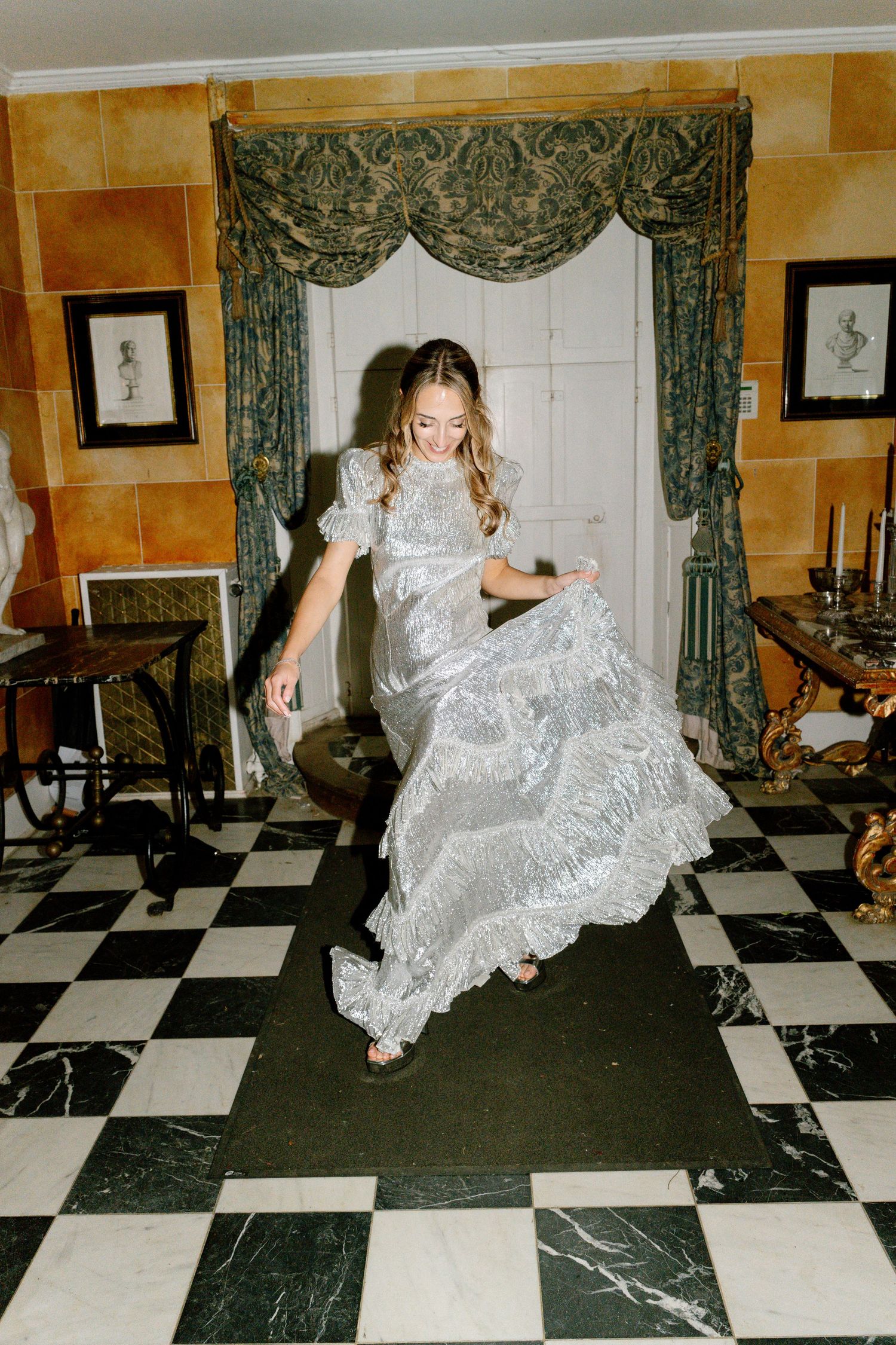 A sequence showing energetic dance movements in a silver dress against a patterned floor.
