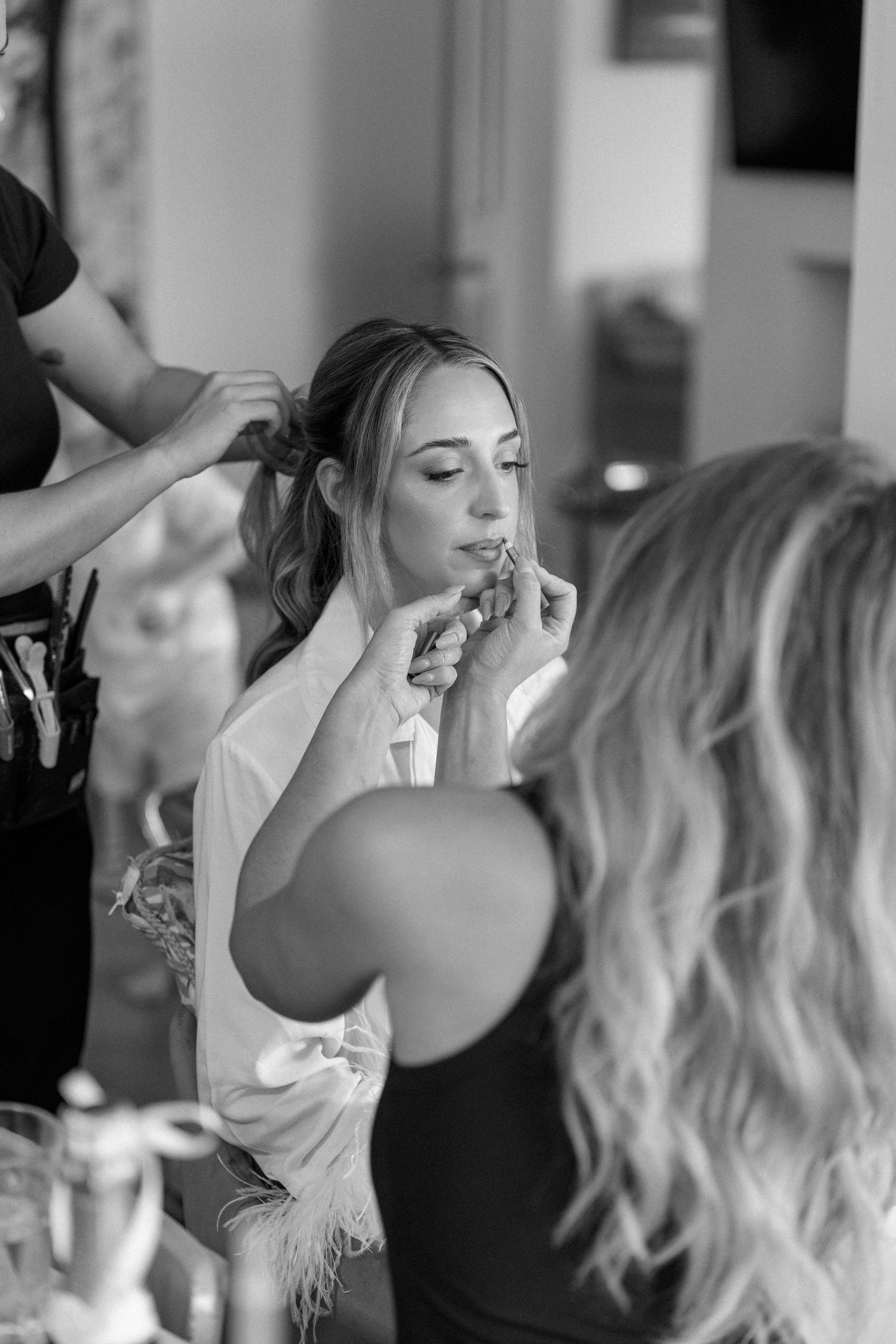 Getting ready scene with professional hair styling in progress.