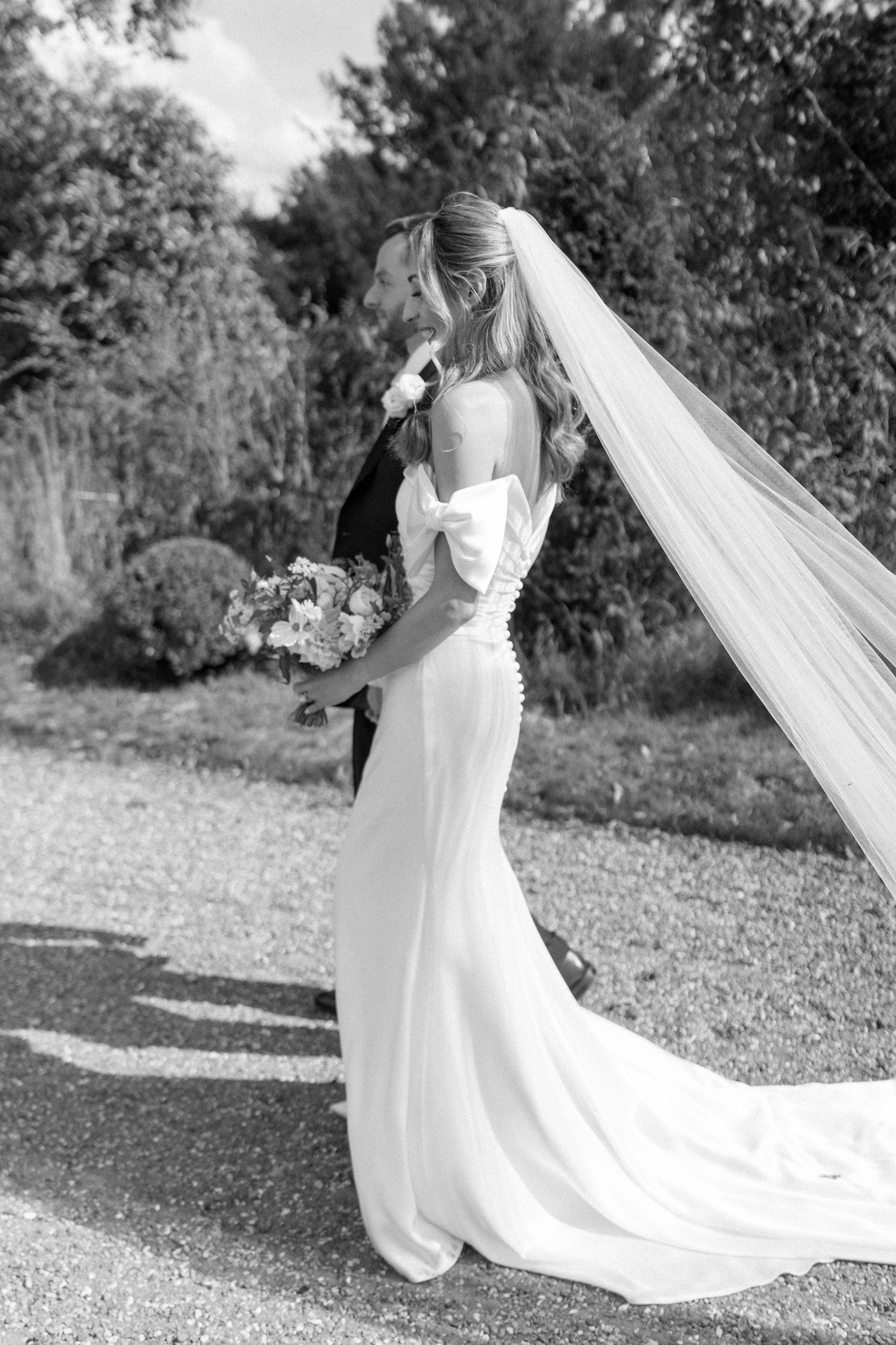 Black and white photos of bride in flowing dress and veil in garden setting.