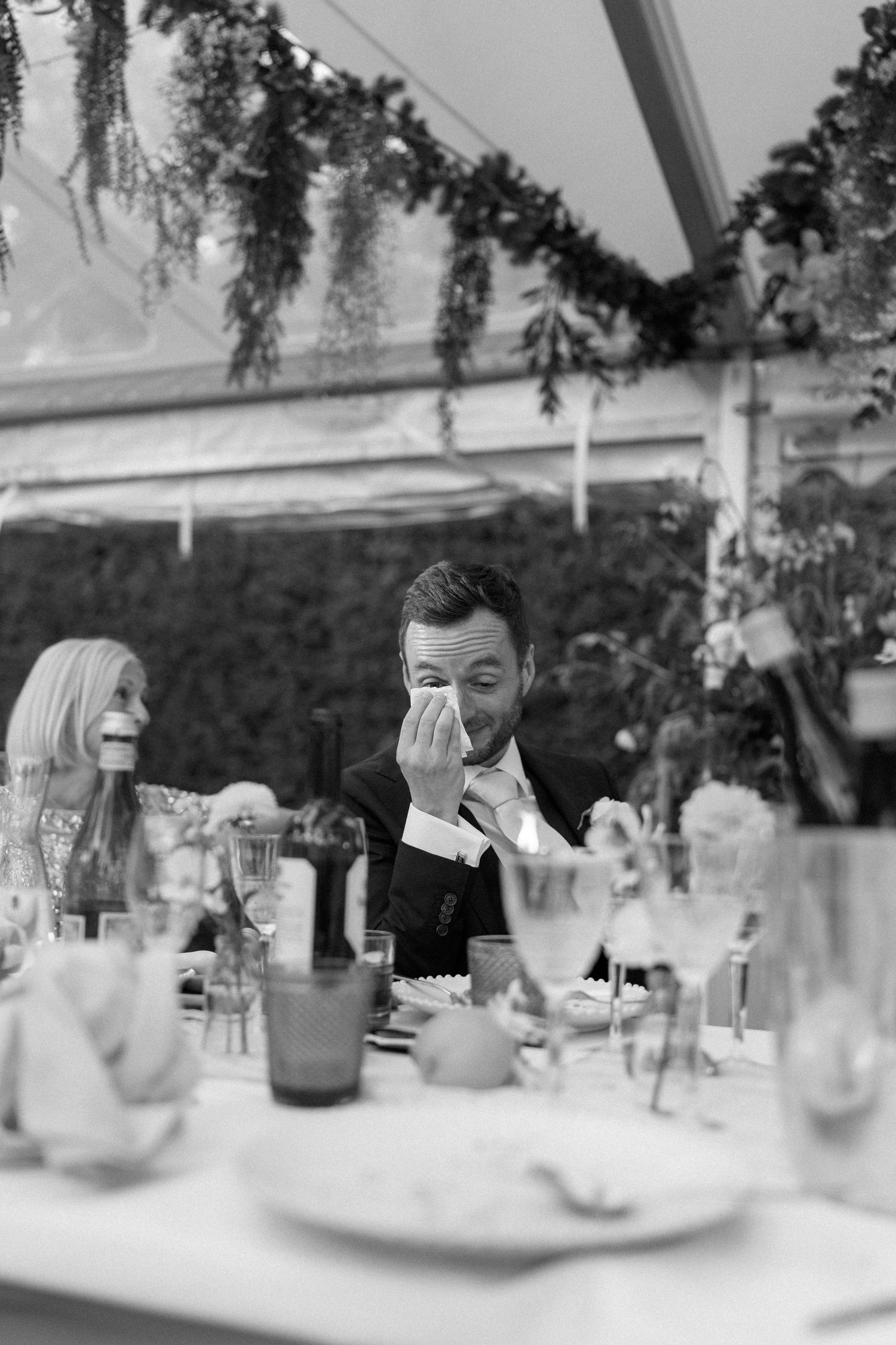 Black and white photo of guests dining at an elegant wedding reception.