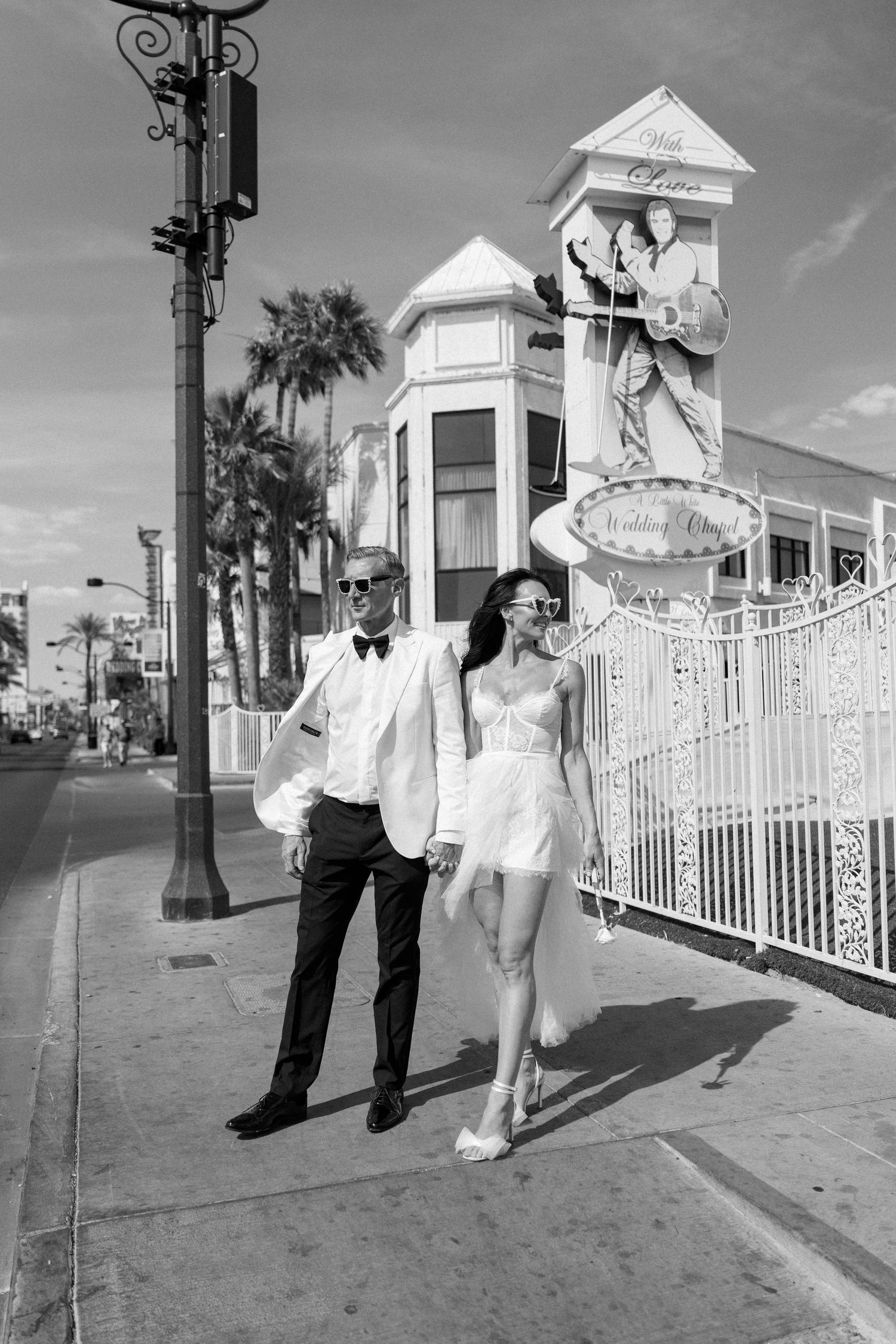 Black and white photo of newlyweds dancing outside Little White Wedding Chapel.