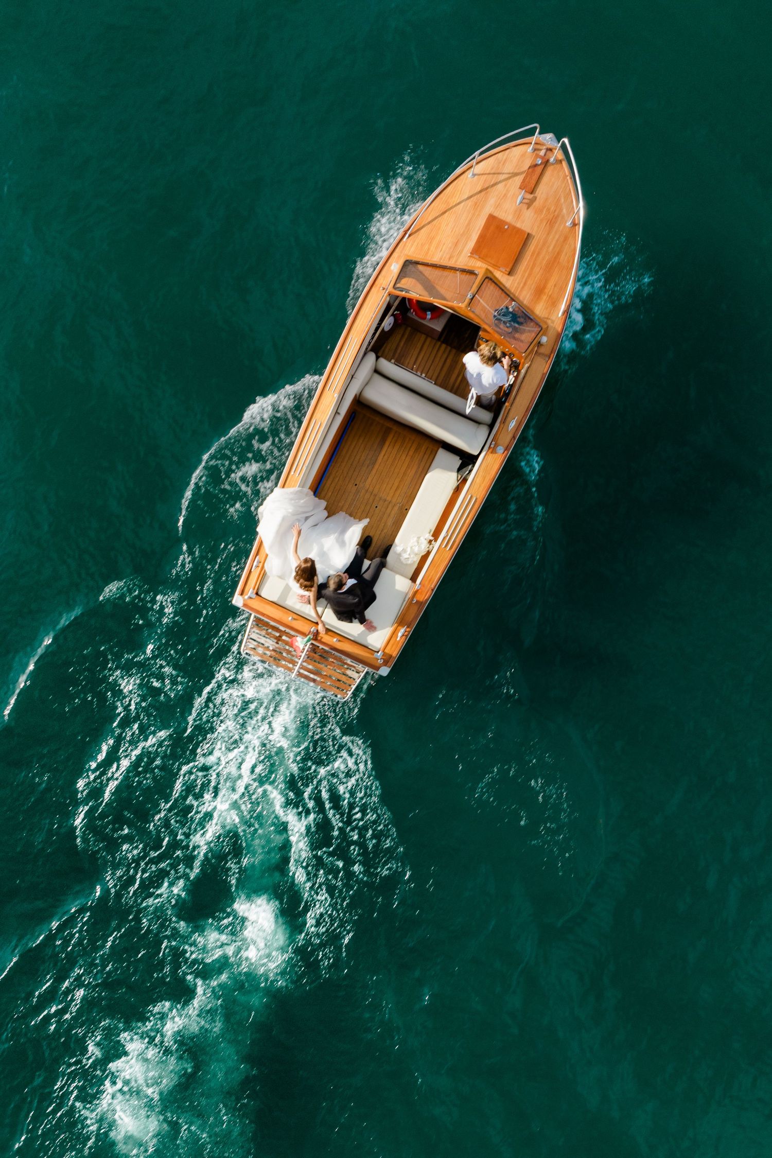 Aerial sequence of a wooden boat moving through turquoise waters.