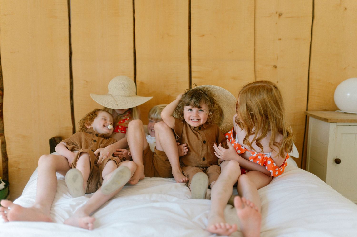 Candid moments captured on a wooden bench in warm lighting.