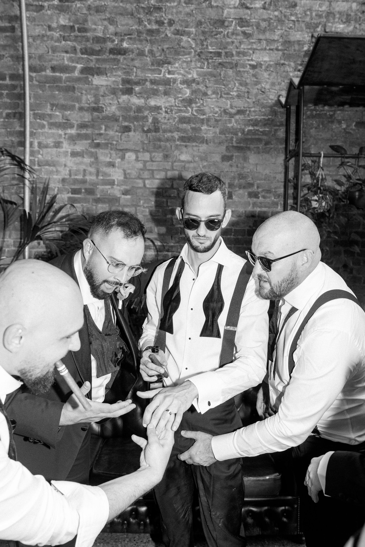 Groomsmen in white shirts and suspenders pose for fun group photos.