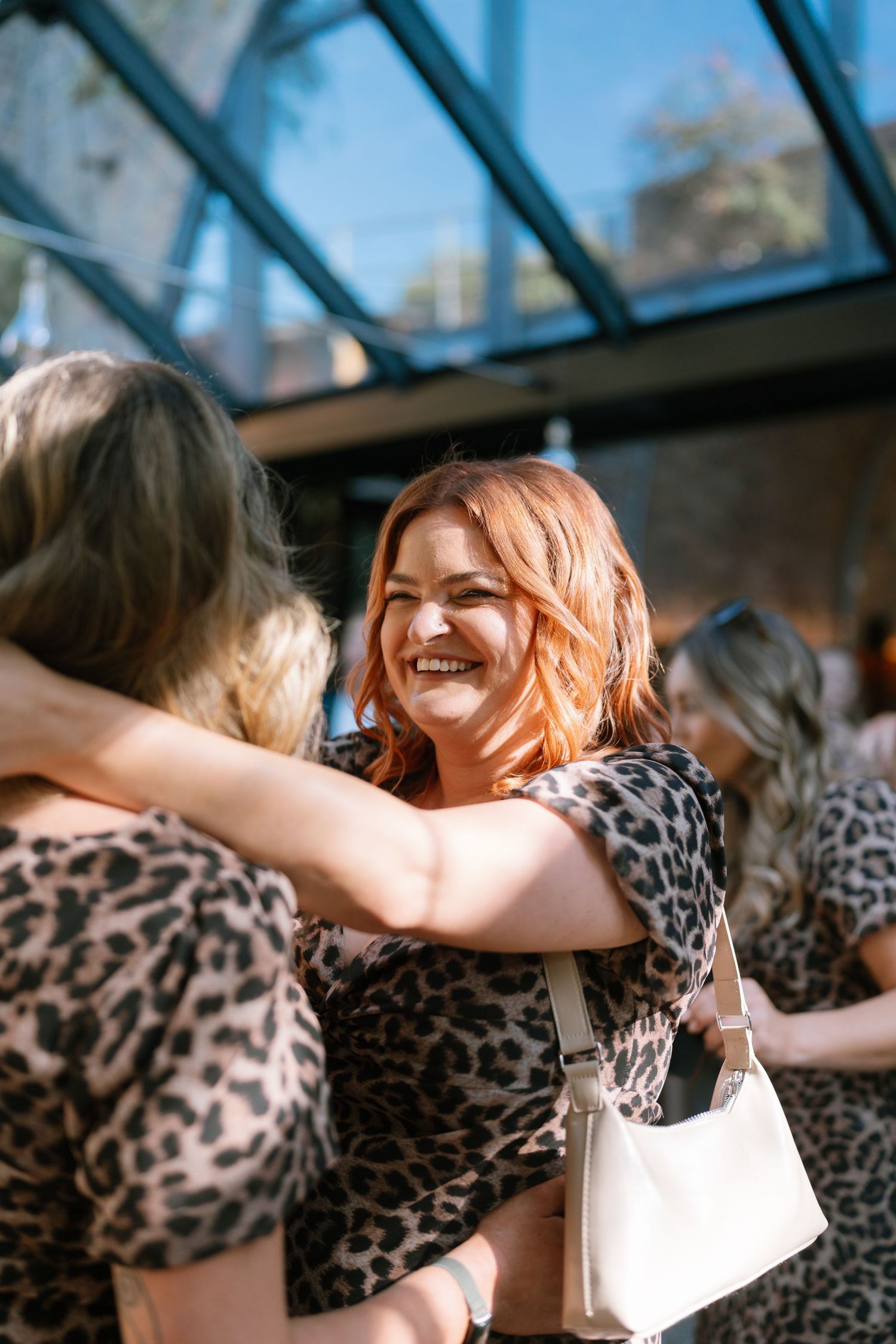 Wedding party members in leopard print dresses dance joyfully.