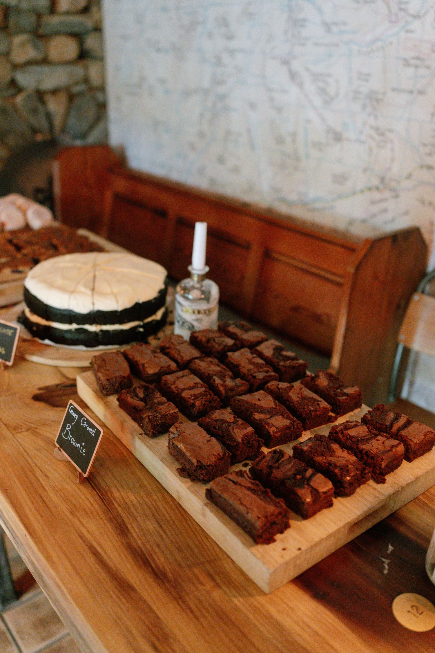 Chocolate brownies displayed on wooden serving boards at a dessert table.