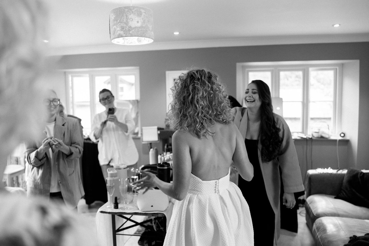 Wedding party preparations in a bright indoor venue with natural lighting.