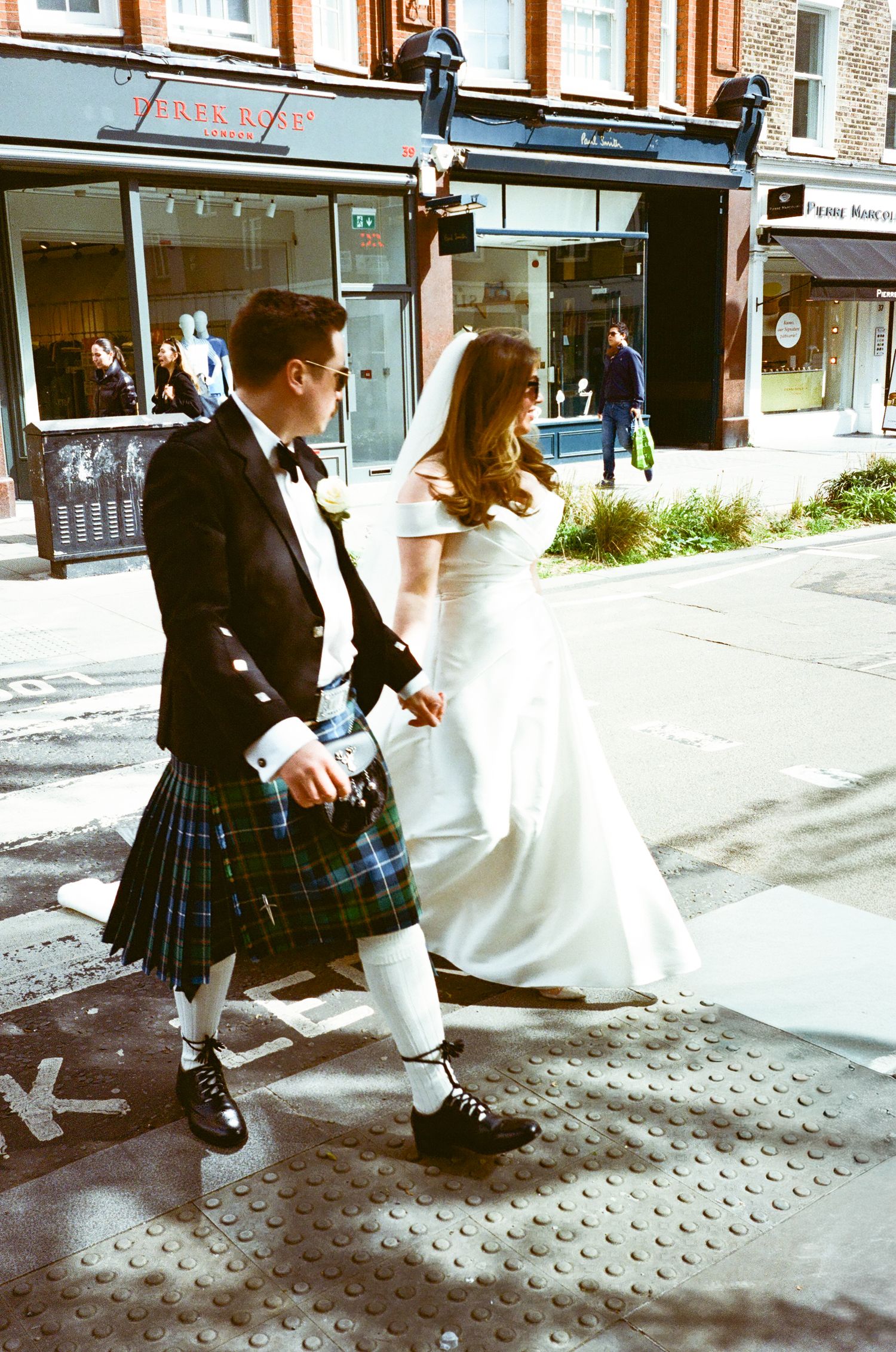 A sequence of photos showing someone in a plaid skirt walking past storefronts on a brick sidewalk.