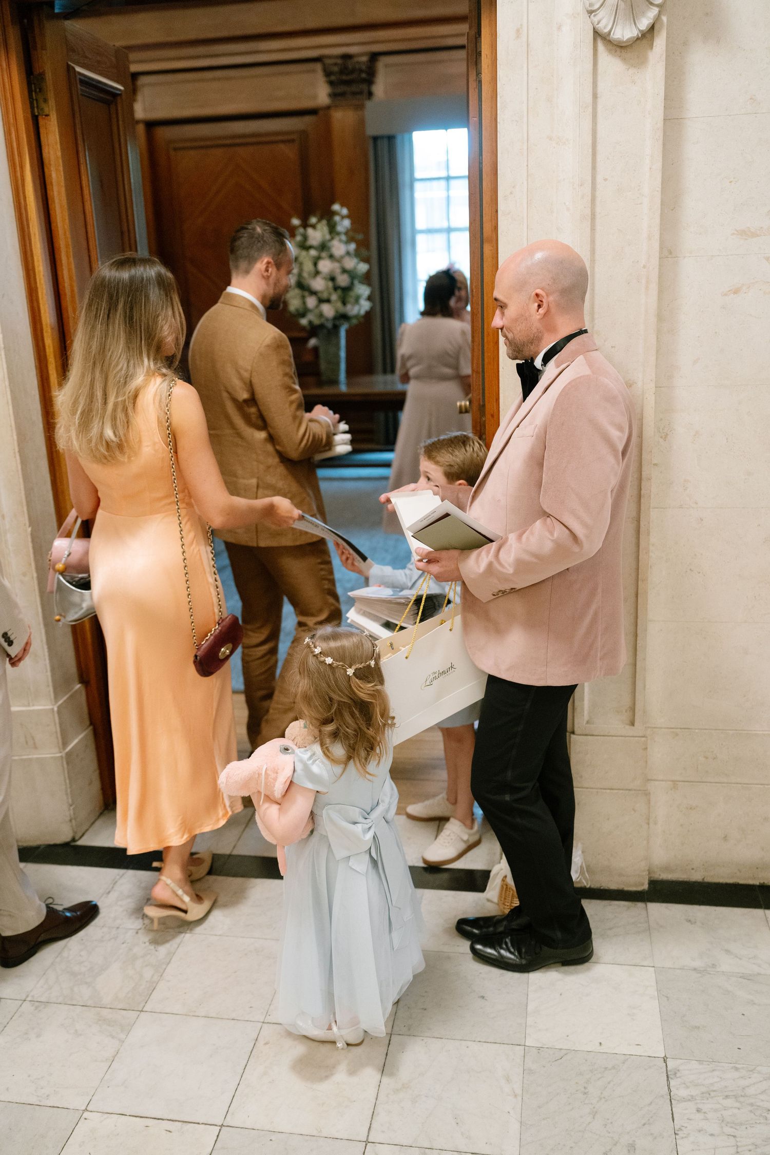 Wedding guests mingling in an elegant marble hallway.