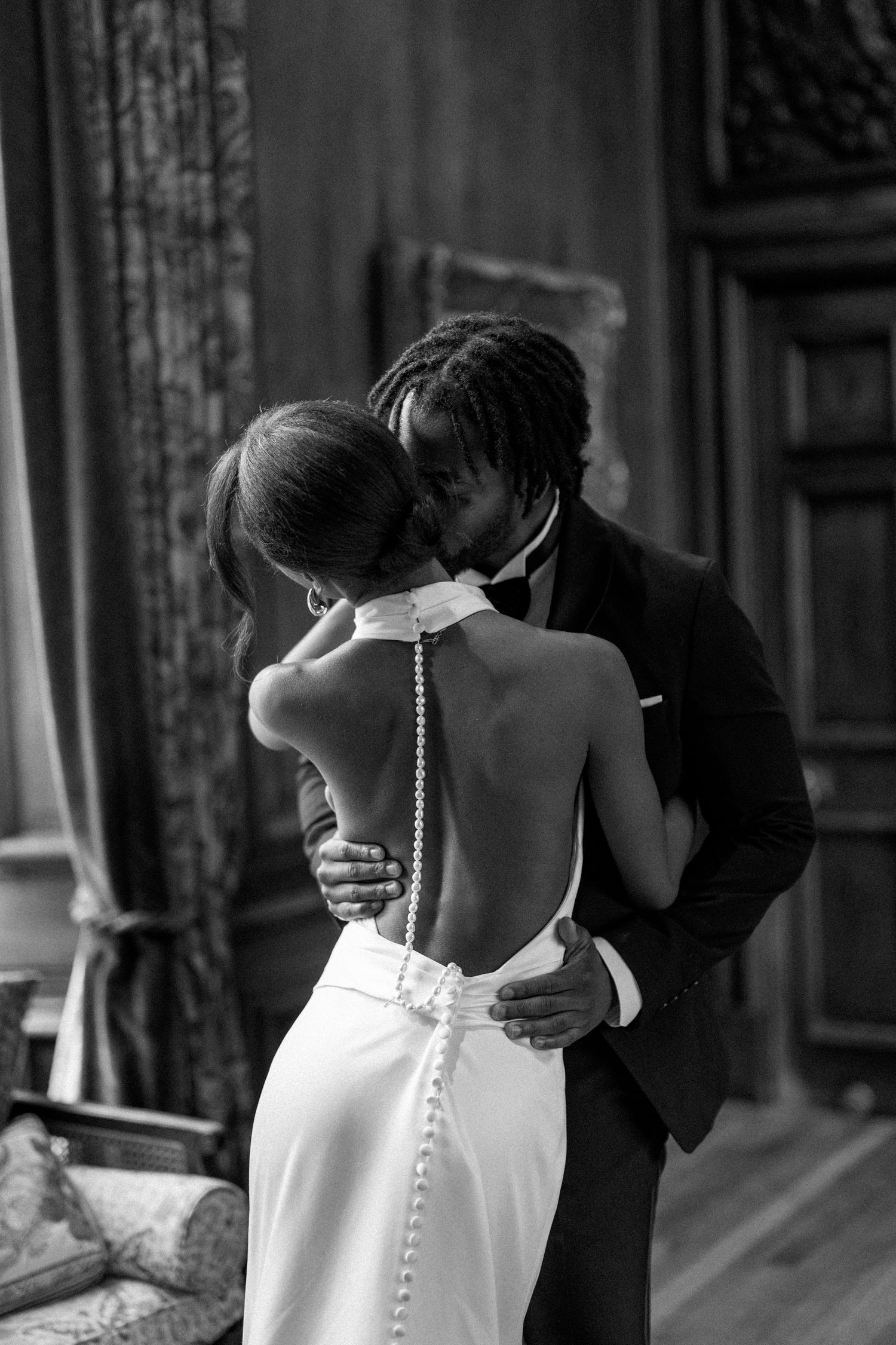 A romantic black and white photo series showing a couple in formal attire embracing in an elegant interior setting.